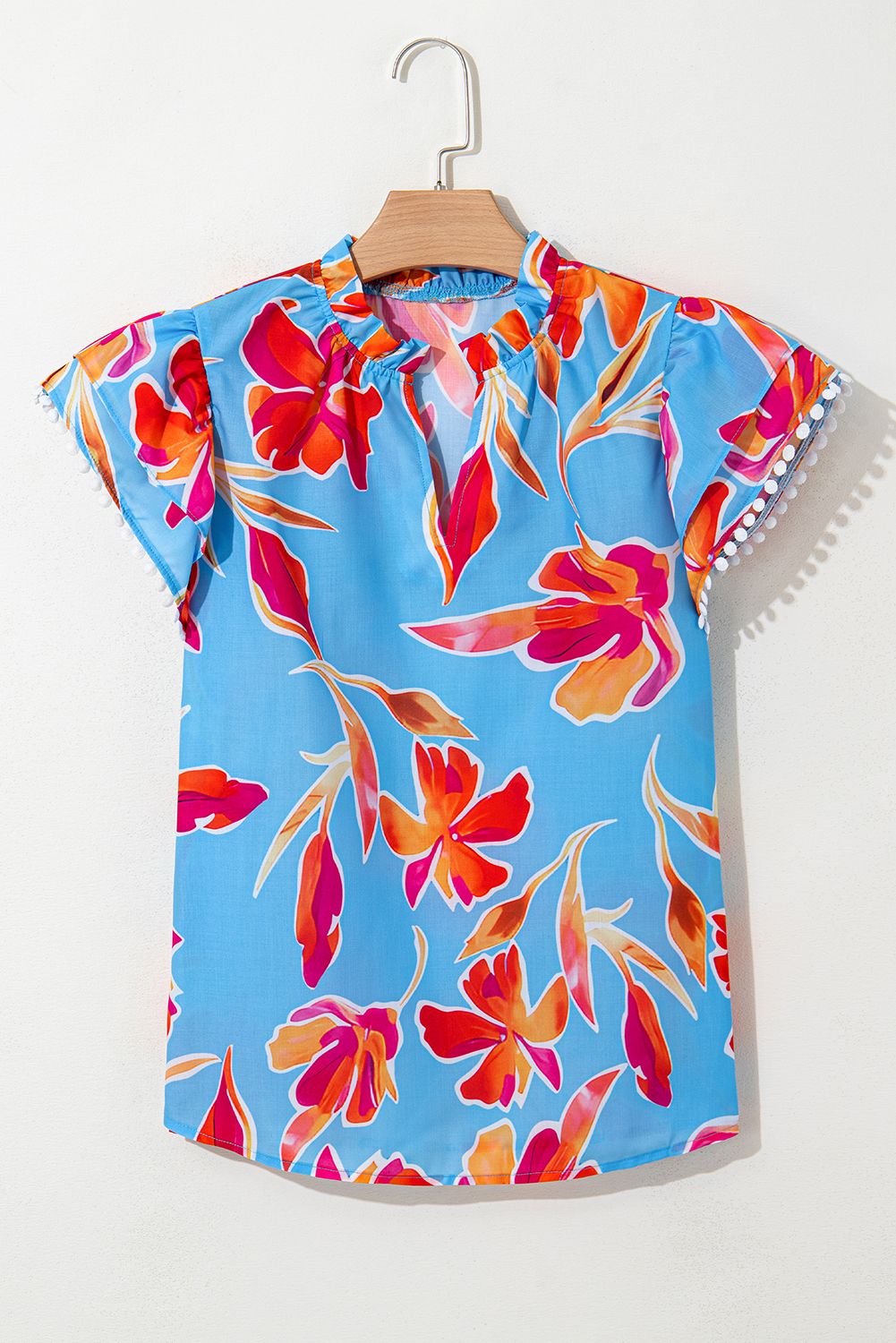 Casual Summer Blouse: Stylish Sky Blue Floral Print with V Neck and Playful Pompom Details - Detail View 2 Casual Summer Blouse: Stylish Sky Blue Floral Print with V Neck and Playful Pompom Details - Detail View 2