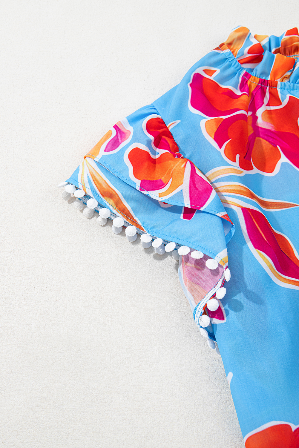 Casual Summer Blouse: Stylish Sky Blue Floral Print with V Neck and Playful Pompom Details - Detail View 6 Casual Summer Blouse: Stylish Sky Blue Floral Print with V Neck and Playful Pompom Details - Detail View 6
