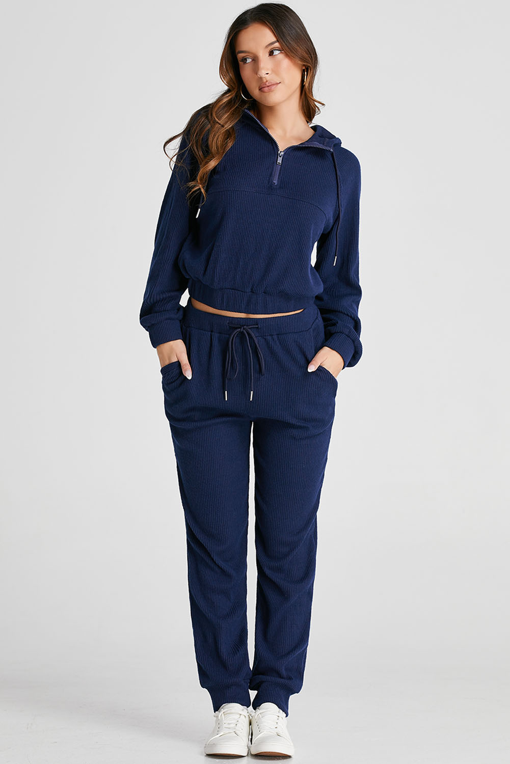 Elevate your activewear collection with this Women's Navy Blue Ribbed Knit Cropped Hoodie and Drawstring Joggers Set. The set includes a cropped hoodie and joggers, offering a coordinated and trendy outfit for your active lifestyle. The stylish ribbed knit design adds a textured look, while the adjustable drawstring on the waist ensures a customized and comfortable fit. Crafted from premium quality fabric, this set provides ultra comfort during workout sessions or casual wear. The hoodie features a hooded neckline and long sleeves, while the joggers come with a high waist and convenient pockets. Versatile and practical, this activewear set is perfect for both workouts and everyday activities. Stay chic and comfortable with this fashionable set in classic navy blue color. - Detail View 9 Elevate your activewear collection with this Women's Navy Blue Ribbed Knit Cropped Hoodie and Drawstring Joggers Set. The set includes a cropped hoodie and joggers, offering a coordinated and trendy outfit for your active lifestyle. The stylish ribbed knit design adds a textured look, while the adjustable drawstring on the waist ensures a customized and comfortable fit. Crafted from premium quality fabric, this set provides ultra comfort during workout sessions or casual wear. The hoodie features a hooded neckline and long sleeves, while the joggers come with a high waist and convenient pockets. Versatile and practical, this activewear set is perfect for both workouts and everyday activities. Stay chic and comfortable with this fashionable set in classic navy blue color. - Detail View 9