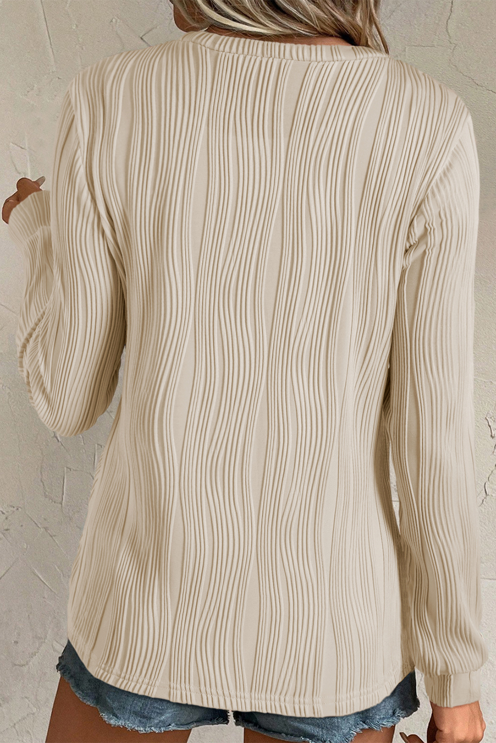 Elevate your casual wardrobe with this Women's Apricot Textured Wavy Round Neck Long Sleeve Top. The intricate wavy fabric adds a distinctive tactile appeal to the classic round neck design. Made from a premium blend of 91% polyester and 9% elastane, this top ensures comfort and durability. The timeless and concise style, along with the solid apricot color, makes it versatile to style and complements any outfit. The long sleeves make it perfect for the fall and autumn seasons, pairing well with fashionable jeans and pants. Whether for a casual day out or a work setting, this top is a must-have addition to your wardrobe, offering both style and comfort. - Detail View 4 Elevate your casual wardrobe with this Women's Apricot Textured Wavy Round Neck Long Sleeve Top. The intricate wavy fabric adds a distinctive tactile appeal to the classic round neck design. Made from a premium blend of 91% polyester and 9% elastane, this top ensures comfort and durability. The timeless and concise style, along with the solid apricot color, makes it versatile to style and complements any outfit. The long sleeves make it perfect for the fall and autumn seasons, pairing well with fashionable jeans and pants. Whether for a casual day out or a work setting, this top is a must-have addition to your wardrobe, offering both style and comfort. - Detail View 4