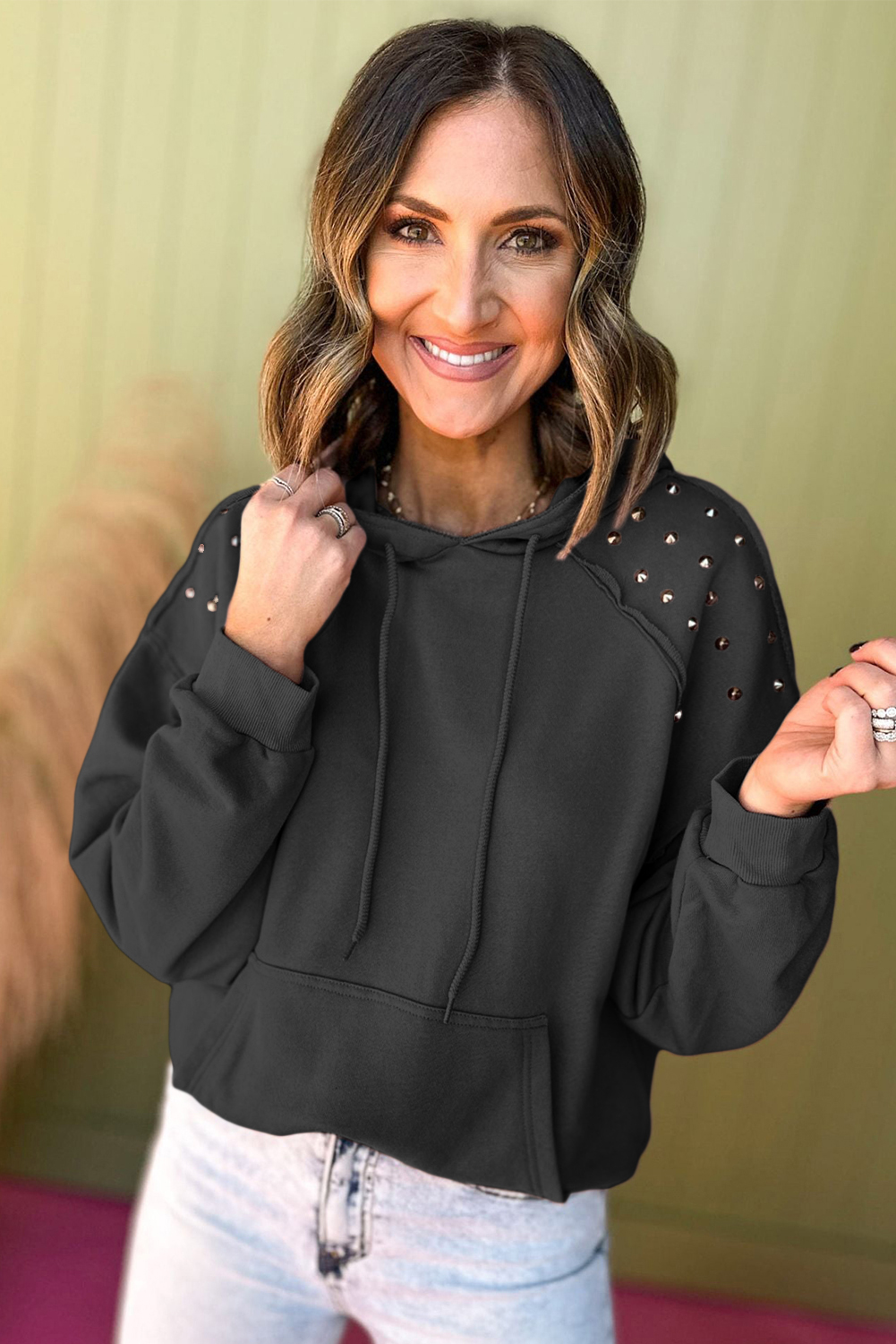 Add a touch of attitude to your daily look with this Women's Black Solid Color Rivet Stud Hoodie with Pocket. The solid black color is versatile and easy to style, while the edgy rivet stud detailing on the sleeves adds a bold and trendy touch. The convenient hood provides added warmth and a stylish vibe, while the practical kangaroo pocket is perfect for storing your essentials. Made from a comfortable blend of 50% polyester and 50% cotton, this hoodie is perfect for daily wear, from casual outings to more dressed-up occasions. With its unique blend of style and functionality, this hoodie is a must-have for your wardrobe. - Detail View 4 Add a touch of attitude to your daily look with this Women's Black Solid Color Rivet Stud Hoodie with Pocket. The solid black color is versatile and easy to style, while the edgy rivet stud detailing on the sleeves adds a bold and trendy touch. The convenient hood provides added warmth and a stylish vibe, while the practical kangaroo pocket is perfect for storing your essentials. Made from a comfortable blend of 50% polyester and 50% cotton, this hoodie is perfect for daily wear, from casual outings to more dressed-up occasions. With its unique blend of style and functionality, this hoodie is a must-have for your wardrobe. - Detail View 4