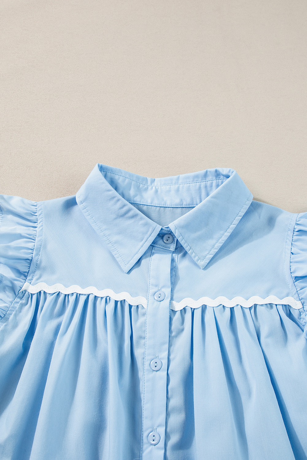 Add a touch of elegance to your daily outfits with this Women's Sleeveless Sky Blue Ric Rac Trim Frilly Shirt. This delightful blend of style and comfort features a classic spread collar and pleat detailing at the front and back, exuding timeless sophistication. The ruffles along the shoulder and armhole provide a subtle feminine touch, while the ric rac trim at the front yoke adds a unique and stylish element. Crafted from a breathable cotton blend fabric, this shirt is lightweight and airy, perfect for warm summer days. With its shift silhouette and sleeveless design, it's easy to style and pair with your favorite bottoms for a chic and effortless look. - Detail View 9 Add a touch of elegance to your daily outfits with this Women's Sleeveless Sky Blue Ric Rac Trim Frilly Shirt. This delightful blend of style and comfort features a classic spread collar and pleat detailing at the front and back, exuding timeless sophistication. The ruffles along the shoulder and armhole provide a subtle feminine touch, while the ric rac trim at the front yoke adds a unique and stylish element. Crafted from a breathable cotton blend fabric, this shirt is lightweight and airy, perfect for warm summer days. With its shift silhouette and sleeveless design, it's easy to style and pair with your favorite bottoms for a chic and effortless look. - Detail View 9