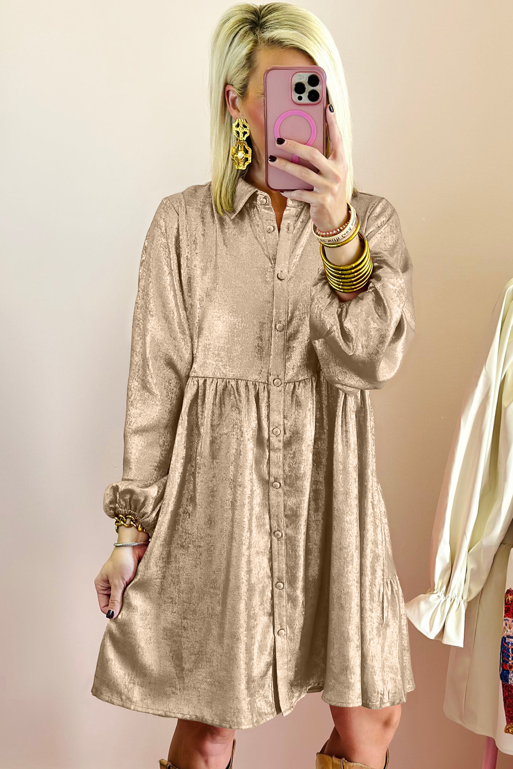 Make a statement at your next special occasion with this Women's Apricot Metallic Sheen Puff Sleeve Button Up Mini Shirt Dress. The luxurious metallic sheen fabric catches the light, while the dramatic puffed sleeves add volume and a touch of regality. The classic button-up front provides easy wear and a polished look. This mini dress is perfect for parties, a night out, or any other formal event where you want to make a glamorous impression. With its elegant design and comfortable fit, this dress is sure to be a standout in your wardrobe. - Detail View 4 Make a statement at your next special occasion with this Women's Apricot Metallic Sheen Puff Sleeve Button Up Mini Shirt Dress. The luxurious metallic sheen fabric catches the light, while the dramatic puffed sleeves add volume and a touch of regality. The classic button-up front provides easy wear and a polished look. This mini dress is perfect for parties, a night out, or any other formal event where you want to make a glamorous impression. With its elegant design and comfortable fit, this dress is sure to be a standout in your wardrobe. - Detail View 4