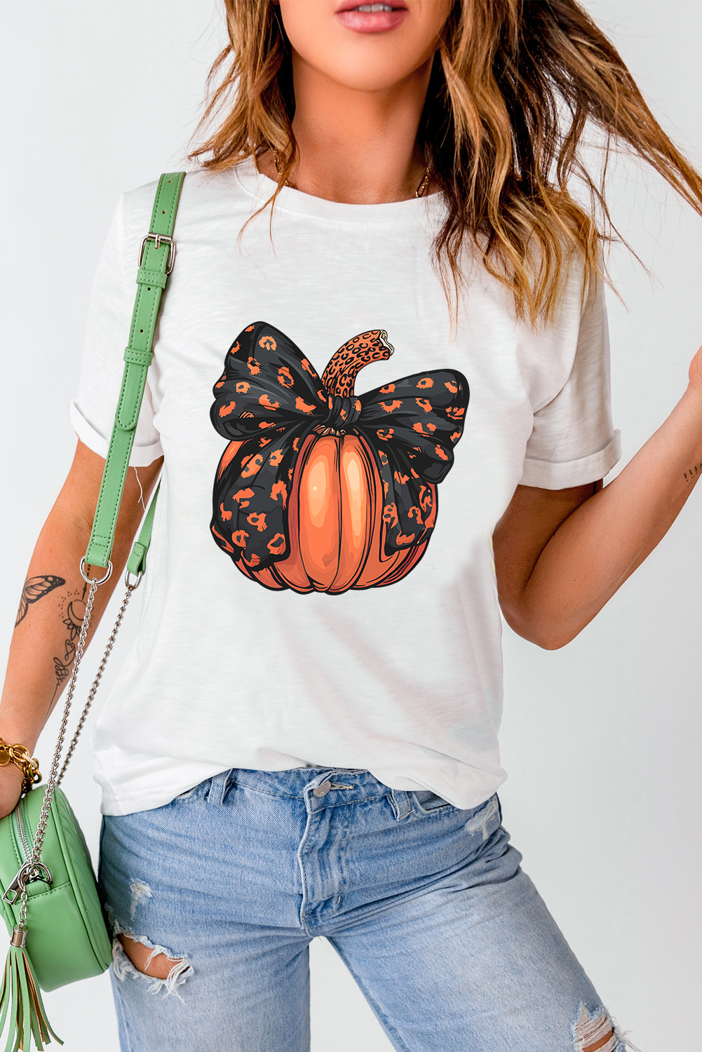Embrace the festive spirit with this Women's White Halloween Pumpkin Graphic Crewneck T-Shirt. The playful pumpkin graphic design adds a cheerful touch, perfect for celebrating the season. Stay comfortable and stylish with the classic crew neck and short sleeves, making it ideal for daily wear. The charming bowknot detail adds a fun twist to your outfit, making this t-shirt a standout piece. Made from a comfortable blend of 62% polyester, 32% cotton, and 6% elastane, this tee ensures a soft and breathable feel. The white color provides a fresh and versatile look, suitable for various occasions. Add a touch of fun and whimsy to your wardrobe with this graphic t-shirt, available in a variety of options to suit your style. - Detail View 9 Embrace the festive spirit with this Women's White Halloween Pumpkin Graphic Crewneck T-Shirt. The playful pumpkin graphic design adds a cheerful touch, perfect for celebrating the season. Stay comfortable and stylish with the classic crew neck and short sleeves, making it ideal for daily wear. The charming bowknot detail adds a fun twist to your outfit, making this t-shirt a standout piece. Made from a comfortable blend of 62% polyester, 32% cotton, and 6% elastane, this tee ensures a soft and breathable feel. The white color provides a fresh and versatile look, suitable for various occasions. Add a touch of fun and whimsy to your wardrobe with this graphic t-shirt, available in a variety of options to suit your style. - Detail View 9