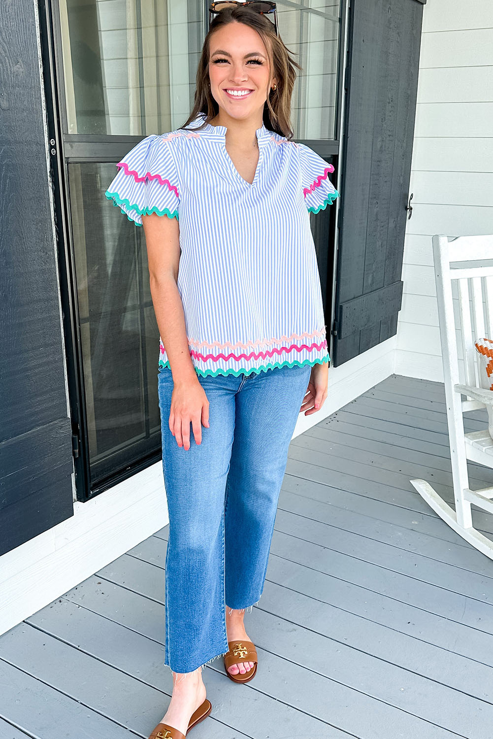 Add a touch of bohemian charm to your wardrobe with this Women's Sky Blue Stripe Ruffled Sleeve Split Neck Blouse with Ric Rac Trim. This striped blouse features intricate ric rac trim that adds a playful and whimsical flair. The split neck design creates a sophisticated and elegant look, while the ruffled sleeves create a feminine and romantic effect. Crafted from 100% cotton, this shirt is both breathable and comfortable to wear. The sky blue stripe pattern is perfect for the summer season, and its chic and casual design makes it suitable for daily wear. Pair it with jeans and sneakers for a relaxed daytime look, or dress it up with tailored pants for a more polished ensemble. This blouse is a must-have addition to your wardrobe, featuring a beautiful combination of colors and styles. - Detail View 4 Add a touch of bohemian charm to your wardrobe with this Women's Sky Blue Stripe Ruffled Sleeve Split Neck Blouse with Ric Rac Trim. This striped blouse features intricate ric rac trim that adds a playful and whimsical flair. The split neck design creates a sophisticated and elegant look, while the ruffled sleeves create a feminine and romantic effect. Crafted from 100% cotton, this shirt is both breathable and comfortable to wear. The sky blue stripe pattern is perfect for the summer season, and its chic and casual design makes it suitable for daily wear. Pair it with jeans and sneakers for a relaxed daytime look, or dress it up with tailored pants for a more polished ensemble. This blouse is a must-have addition to your wardrobe, featuring a beautiful combination of colors and styles. - Detail View 4