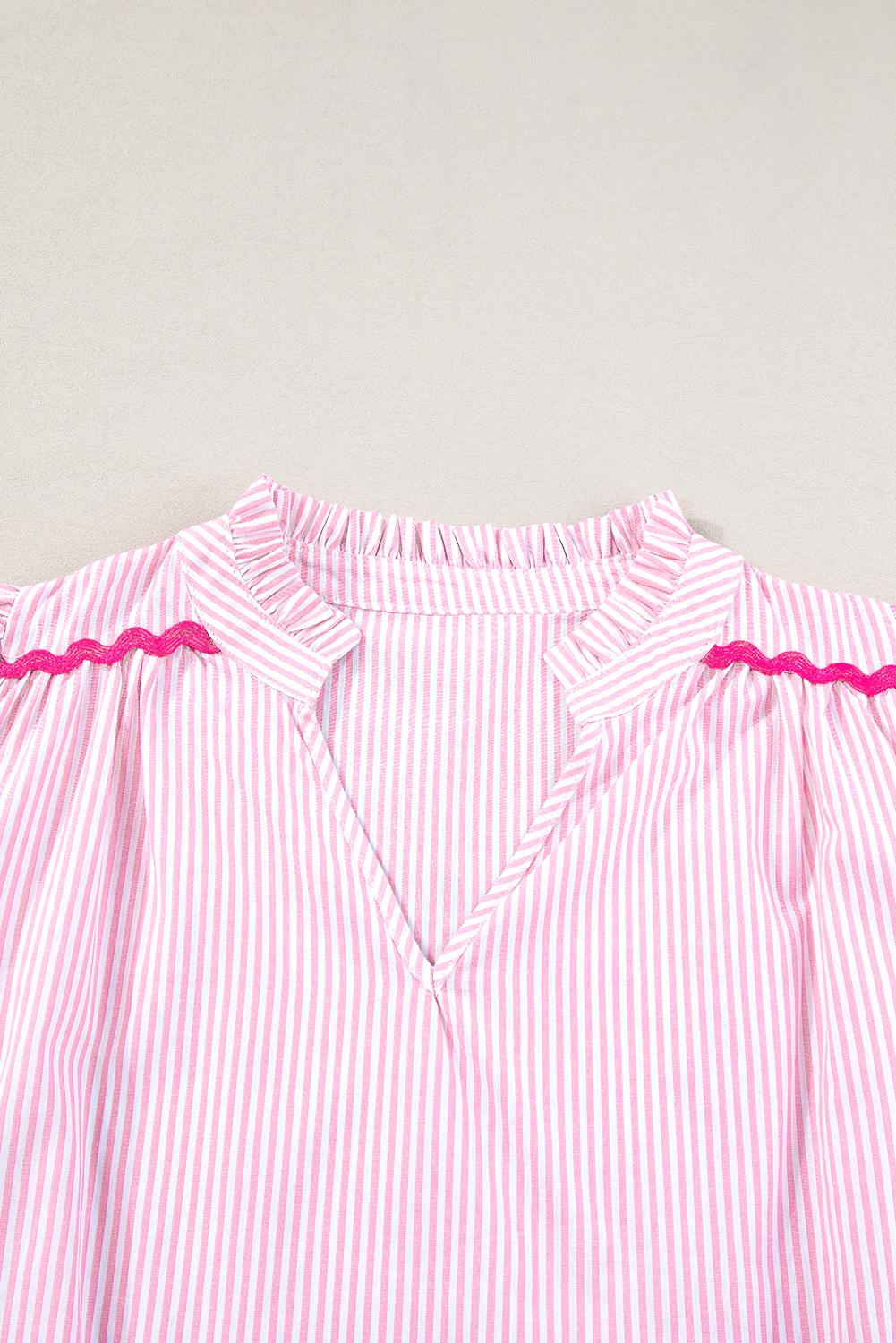 Elevate your everyday style with this charming Pink Stripe Ricrac Trim Split Neck Striped Ruffled Sleeve Blouse. The intricately designed ric rac trim adds a touch of bohemian charm, while the split neck design exudes sophistication. The ruffled sleeves create a whimsical and feminine effect, making this blouse a perfect combination of chic and casual. Made from 100% cotton, this blouse ensures breathability and comfort. The pink and white stripe pattern is both playful and fashion forward, perfect for the spring season. Whether you're heading to work or a casual outing, this blouse is sure to turn heads. Its feminine silhouette, V-neckline, and short sleeve length make it a must-have addition to your wardrobe. - Detail View 9 Elevate your everyday style with this charming Pink Stripe Ricrac Trim Split Neck Striped Ruffled Sleeve Blouse. The intricately designed ric rac trim adds a touch of bohemian charm, while the split neck design exudes sophistication. The ruffled sleeves create a whimsical and feminine effect, making this blouse a perfect combination of chic and casual. Made from 100% cotton, this blouse ensures breathability and comfort. The pink and white stripe pattern is both playful and fashion forward, perfect for the spring season. Whether you're heading to work or a casual outing, this blouse is sure to turn heads. Its feminine silhouette, V-neckline, and short sleeve length make it a must-have addition to your wardrobe. - Detail View 9