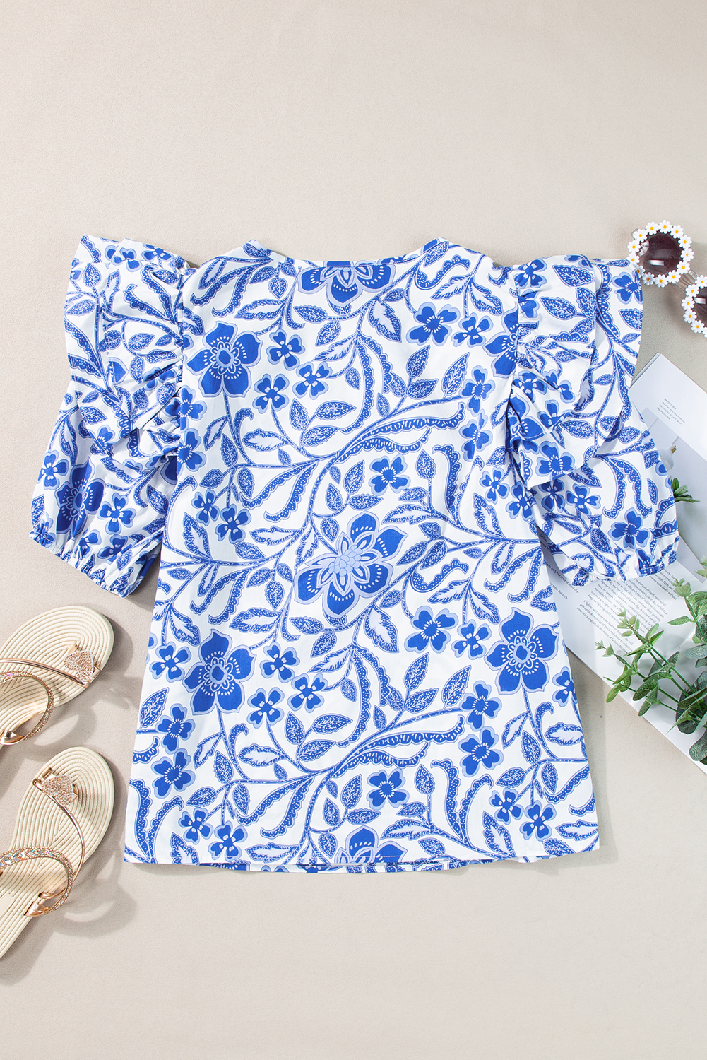Elevate your wardrobe with this Women's Dark Blue Floral Print Ruffled Bubble Sleeve Blouse. Featuring a charming floral print, this blouse creates an eye-catching and feminine look. The playful ruffled bubble sleeves add a touch of whimsy and flair to the top, while the stylish notched neck detail provides a modern twist. Embrace elegance with the bubble sleeve design, adding a chic and sophisticated element to your outfit. Made from 100% cotton, this blouse ensures comfort and breathability for all-day wear. Perfect for daily occasions and summer outings, this versatile blouse is a must-have for any fashion-forward woman looking to update her wardrobe with on-trend styles. - Detail View 9 Elevate your wardrobe with this Women's Dark Blue Floral Print Ruffled Bubble Sleeve Blouse. Featuring a charming floral print, this blouse creates an eye-catching and feminine look. The playful ruffled bubble sleeves add a touch of whimsy and flair to the top, while the stylish notched neck detail provides a modern twist. Embrace elegance with the bubble sleeve design, adding a chic and sophisticated element to your outfit. Made from 100% cotton, this blouse ensures comfort and breathability for all-day wear. Perfect for daily occasions and summer outings, this versatile blouse is a must-have for any fashion-forward woman looking to update her wardrobe with on-trend styles. - Detail View 9