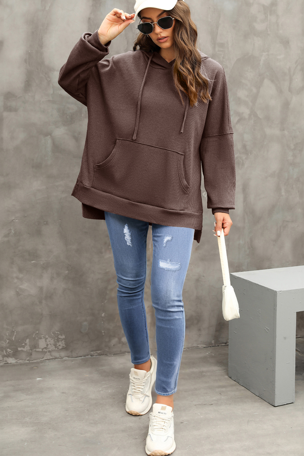 Stay warm and stylish in the colder months with this Women's Coffee Waffle Knit Fleece Lined High Low Oversized Hoodie. The soft jacquard knit fabric creates a cozy feel, while the outstanding fleece-lined design provides warmth and comfort. The stylish high low design and oversized fit enhance a casual and slender silhouette, making it a fashionable and comfortable choice for fall and winter. The convenient kangaroo pocket not only adds a decorative element but also provides storage for your essentials. Made from a premium blend of 75% polyester and 25% cotton, this hoodie ensures durability and breathability. The versatile design makes it perfect for daily wear, offering both style and comfort. Stay cozy and chic with this must-have coffee-colored hoodie. - Detail View 9 Stay warm and stylish in the colder months with this Women's Coffee Waffle Knit Fleece Lined High Low Oversized Hoodie. The soft jacquard knit fabric creates a cozy feel, while the outstanding fleece-lined design provides warmth and comfort. The stylish high low design and oversized fit enhance a casual and slender silhouette, making it a fashionable and comfortable choice for fall and winter. The convenient kangaroo pocket not only adds a decorative element but also provides storage for your essentials. Made from a premium blend of 75% polyester and 25% cotton, this hoodie ensures durability and breathability. The versatile design makes it perfect for daily wear, offering both style and comfort. Stay cozy and chic with this must-have coffee-colored hoodie. - Detail View 9