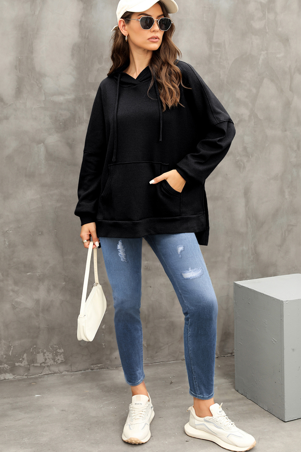 Elevate your casual style with this Women's Black Waffle Knit Fleece Lined High-Low Oversized Hoodie. The soft jacquard knit fabric creates a cozy feel, perfect for the colder seasons. The stylish high-low design and oversized fit enhance a casual and slender silhouette, while the outstanding fleece lining provides warmth and comfort. The convenient kangaroo pocket not only offers storage but also adds a decorative element to the hoodie. Made from a blend of 75% polyester and 25% cotton, this hoodie ensures durability and a comfortable fit. The solid black color and hooded neckline make it a versatile addition to your fall and winter wardrobe. Perfect for daily wear, this hoodie is a must-have for staying warm and stylish during the colder months. - Detail View 9 Elevate your casual style with this Women's Black Waffle Knit Fleece Lined High-Low Oversized Hoodie. The soft jacquard knit fabric creates a cozy feel, perfect for the colder seasons. The stylish high-low design and oversized fit enhance a casual and slender silhouette, while the outstanding fleece lining provides warmth and comfort. The convenient kangaroo pocket not only offers storage but also adds a decorative element to the hoodie. Made from a blend of 75% polyester and 25% cotton, this hoodie ensures durability and a comfortable fit. The solid black color and hooded neckline make it a versatile addition to your fall and winter wardrobe. Perfect for daily wear, this hoodie is a must-have for staying warm and stylish during the colder months. - Detail View 9