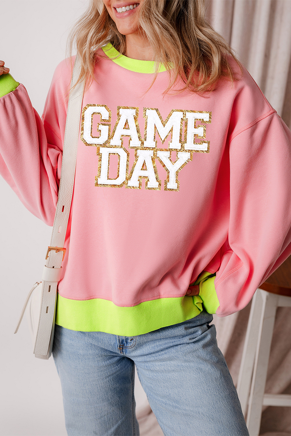 Get ready to elevate your game day style with this Women's Pink Glitter Game Day Color Block Crew Neck Sweatshirt. The mesmerizing glitter graphic adds a touch of excitement and flair to your outfit, while the color block edges create a stylish contrasting effect. Made from a comfortable blend of 50% polyester and 50% cotton, this sweatshirt is perfect for casual wear with jeans or denim shorts. The round neckline and long sleeves ensure a comfortable fit, and the colorblock design keeps you warm and cozy on a chilly game day. Whether you're cheering on your favorite team or running errands, this graphic sweatshirt is a must-have for any sports enthusiast. - Detail View 4 Get ready to elevate your game day style with this Women's Pink Glitter Game Day Color Block Crew Neck Sweatshirt. The mesmerizing glitter graphic adds a touch of excitement and flair to your outfit, while the color block edges create a stylish contrasting effect. Made from a comfortable blend of 50% polyester and 50% cotton, this sweatshirt is perfect for casual wear with jeans or denim shorts. The round neckline and long sleeves ensure a comfortable fit, and the colorblock design keeps you warm and cozy on a chilly game day. Whether you're cheering on your favorite team or running errands, this graphic sweatshirt is a must-have for any sports enthusiast. - Detail View 4