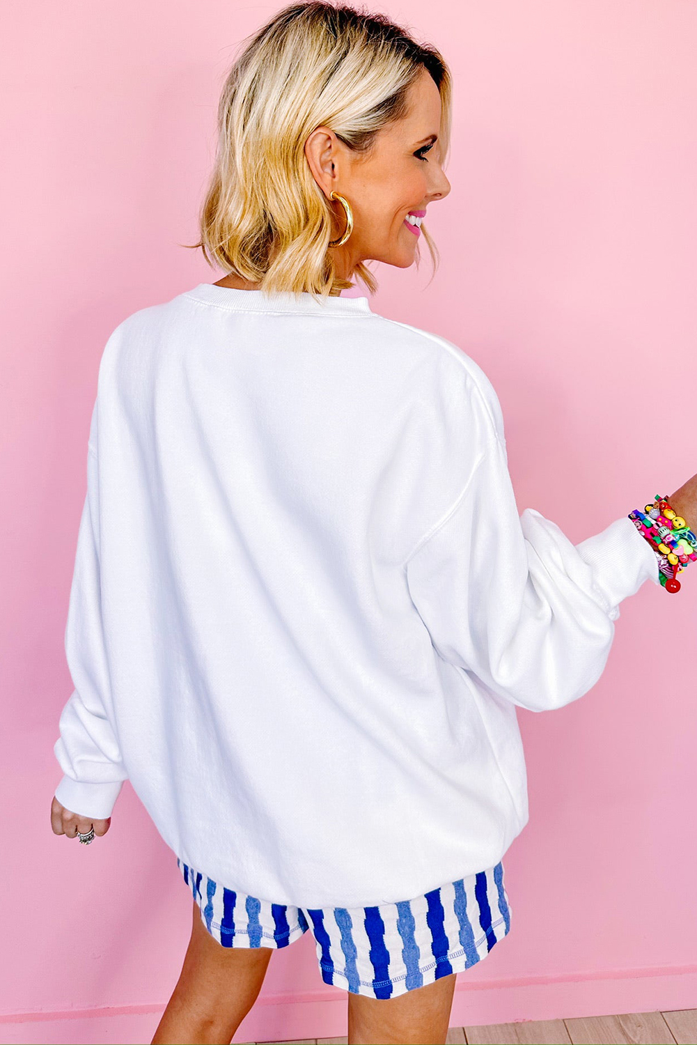 Show your American pride with this stunning White American Flag Graphic Drop Shoulder Loose Sweatshirt. The outstanding flag pattern on the front is a perfect way to express your patriotic enthusiasm. The round neck, drop shoulder, and relaxed fit style give the sweatshirt a comfortable and casual look. Pair it with your favorite pants for a stylish and cozy outfit. Made from a soft blend of 50% polyester and 50% cotton, this sweatshirt is perfect for fall and winter wear. It's a must-have addition to your wardrobe, featuring a stylish graphic and a comfortable fit. - Detail View 4 Show your American pride with this stunning White American Flag Graphic Drop Shoulder Loose Sweatshirt. The outstanding flag pattern on the front is a perfect way to express your patriotic enthusiasm. The round neck, drop shoulder, and relaxed fit style give the sweatshirt a comfortable and casual look. Pair it with your favorite pants for a stylish and cozy outfit. Made from a soft blend of 50% polyester and 50% cotton, this sweatshirt is perfect for fall and winter wear. It's a must-have addition to your wardrobe, featuring a stylish graphic and a comfortable fit. - Detail View 4