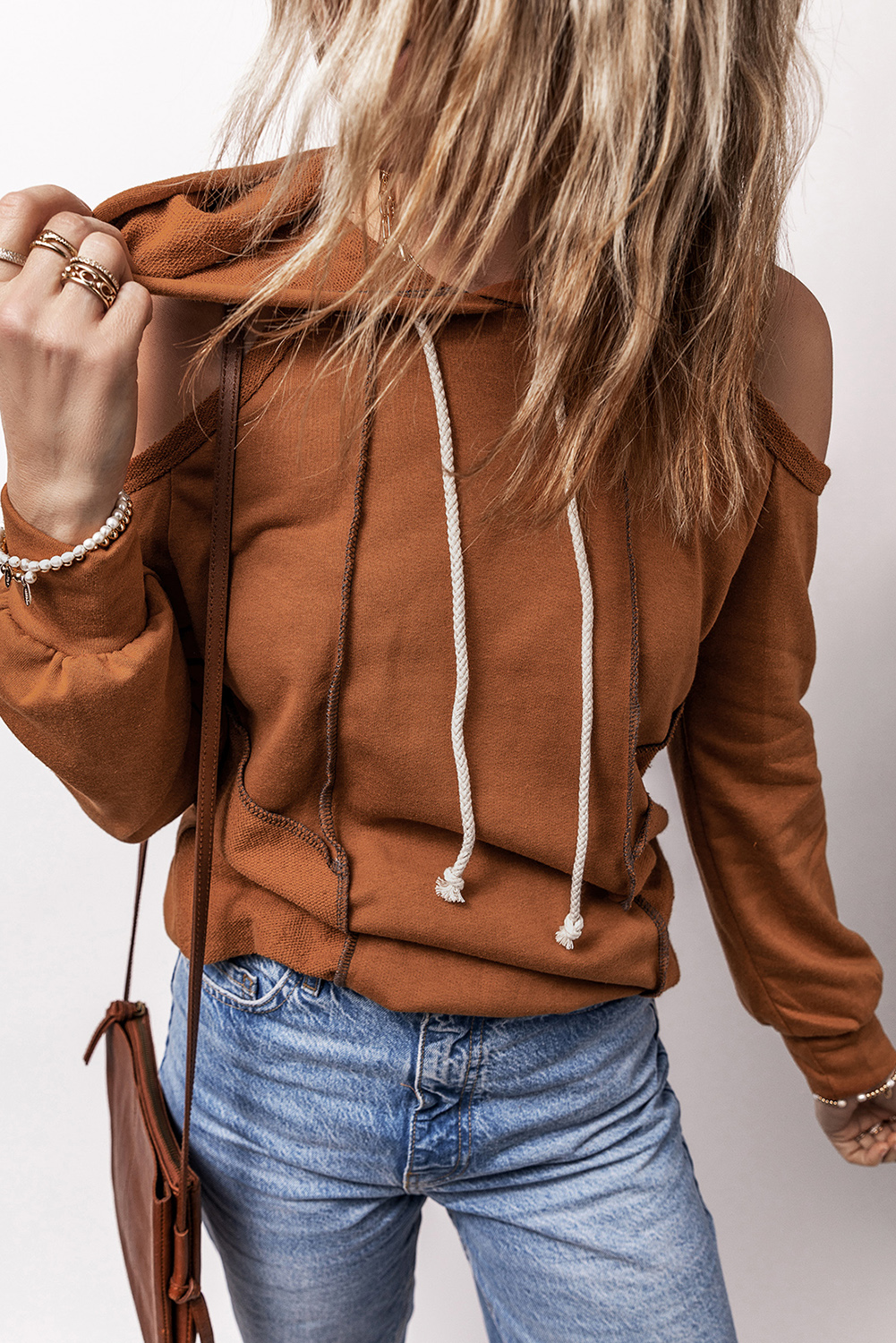 Stand out from the crowd with this Women's Cinnamon Exposed Seam Cold Shoulder Drawstring Hoodie. The unique cold shoulder design adds a touch of femininity, while the exposed seam detailing elevates the overall look. The drawstring hood allows for adjustable comfort, making it perfect for daily wear. Pair this hoodie with jeans or denim shorts for a chic and effortless ensemble. The 70% polyester and 30% cotton material ensures durability and softness. Whether you're heading out for a casual dinner or just lounging around, this hoodie is a must-have for your wardrobe. - Detail View 4 Stand out from the crowd with this Women's Cinnamon Exposed Seam Cold Shoulder Drawstring Hoodie. The unique cold shoulder design adds a touch of femininity, while the exposed seam detailing elevates the overall look. The drawstring hood allows for adjustable comfort, making it perfect for daily wear. Pair this hoodie with jeans or denim shorts for a chic and effortless ensemble. The 70% polyester and 30% cotton material ensures durability and softness. Whether you're heading out for a casual dinner or just lounging around, this hoodie is a must-have for your wardrobe. - Detail View 4