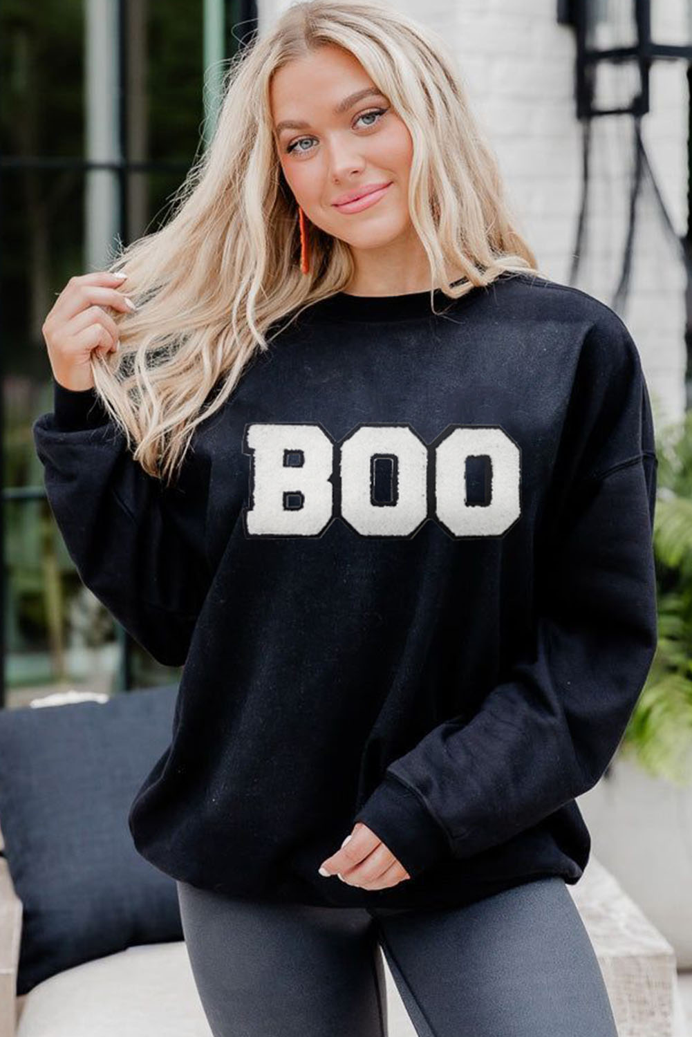 Get into the spirit of Halloween with this Women's Black Chenille BOO Patched Pattern Crewneck Sweatshirt. The chenille BOO patched pattern adds a unique and textured touch to the sweatshirt, making it a great choice for the spooky season. The crew neck and drop shoulder design provide a comfortable fit, while the soft and warm material ensures a cozy wear. This graphic sweatshirt is perfect for those who love to express their festive spirit and celebrate Halloween. Whether you're going to a party or just want to stay warm and cozy, this sweatshirt is a great addition to your wardrobe. - Detail View 4 Get into the spirit of Halloween with this Women's Black Chenille BOO Patched Pattern Crewneck Sweatshirt. The chenille BOO patched pattern adds a unique and textured touch to the sweatshirt, making it a great choice for the spooky season. The crew neck and drop shoulder design provide a comfortable fit, while the soft and warm material ensures a cozy wear. This graphic sweatshirt is perfect for those who love to express their festive spirit and celebrate Halloween. Whether you're going to a party or just want to stay warm and cozy, this sweatshirt is a great addition to your wardrobe. - Detail View 4