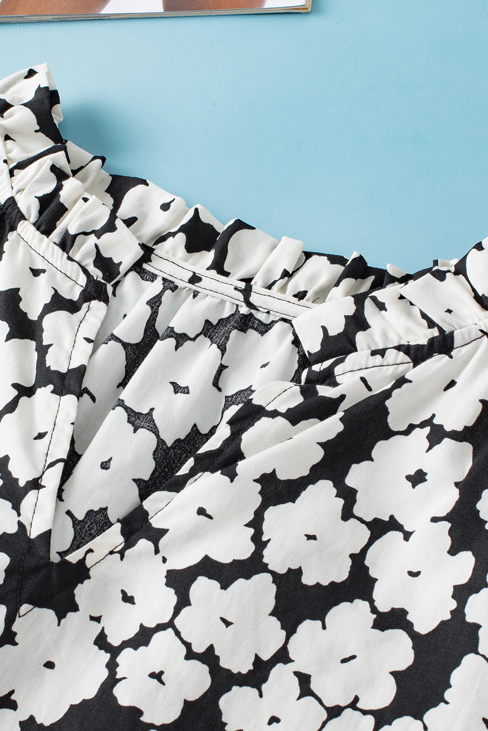 Make a statement with this Women's Black Floral Contrast Ric Rac Layered Ruffle Sleeve Blouse. The floral print, V-neck, and short sleeves with tiered ruffle detail exude femininity and charm. The contrast ric rac trim adds intricate detail, making this blouse delicate and unique. Its exclusive floral pattern makes it a gorgeous and appealing choice for both casual and dressy occasions, allowing you to stand out in style. Made from premium 100% cotton, this blouse ensures comfort and breathability, ideal for the summer season. The black color adds a touch of sophistication and versatility to your wardrobe. Pair it with your favorite bottoms for a chic and trendy look. This stylish blouse with unique patterns and designs is a must-have addition to your collection. - Detail View 4 Make a statement with this Women's Black Floral Contrast Ric Rac Layered Ruffle Sleeve Blouse. The floral print, V-neck, and short sleeves with tiered ruffle detail exude femininity and charm. The contrast ric rac trim adds intricate detail, making this blouse delicate and unique. Its exclusive floral pattern makes it a gorgeous and appealing choice for both casual and dressy occasions, allowing you to stand out in style. Made from premium 100% cotton, this blouse ensures comfort and breathability, ideal for the summer season. The black color adds a touch of sophistication and versatility to your wardrobe. Pair it with your favorite bottoms for a chic and trendy look. This stylish blouse with unique patterns and designs is a must-have addition to your collection. - Detail View 4