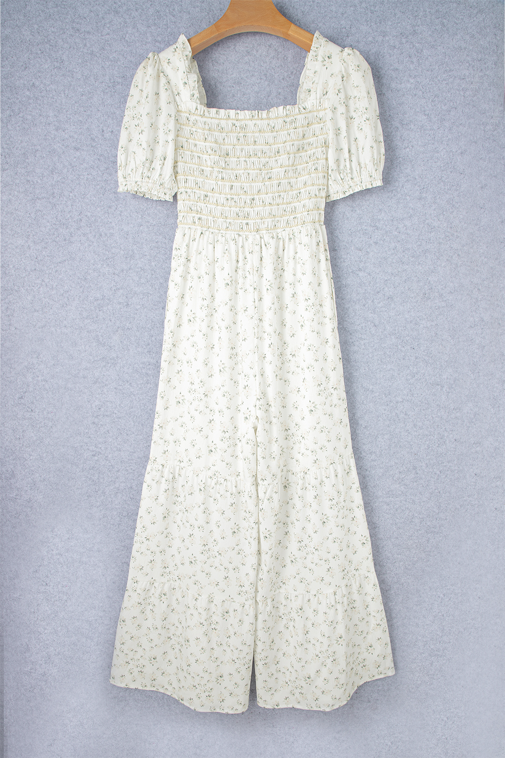 Elevate your style with this exquisite Women's Boho White Floral Smocked Wide Leg Short Puff Sleeve Jumpsuit. The fresh floral design and square neck make it a perfect choice for summer occasions. The smocked bodice adds a touch of sophistication, while the short puff sleeves and high waist provide a flattering fit. The wide leg design ensures a comfortable and stylish silhouette. This jumpsuit is perfect for casual or dressy holidays, and its popularity extends to various occasions. Made from premium 100% polyester, this jumpsuit ensures durability and comfort. Pair it with heels for a more polished look or sneakers for a casual ensemble. Its delicate cuttings and attractive prices make it a must-have addition to your wardrobe. - Detail View 4 Elevate your style with this exquisite Women's Boho White Floral Smocked Wide Leg Short Puff Sleeve Jumpsuit. The fresh floral design and square neck make it a perfect choice for summer occasions. The smocked bodice adds a touch of sophistication, while the short puff sleeves and high waist provide a flattering fit. The wide leg design ensures a comfortable and stylish silhouette. This jumpsuit is perfect for casual or dressy holidays, and its popularity extends to various occasions. Made from premium 100% polyester, this jumpsuit ensures durability and comfort. Pair it with heels for a more polished look or sneakers for a casual ensemble. Its delicate cuttings and attractive prices make it a must-have addition to your wardrobe. - Detail View 4