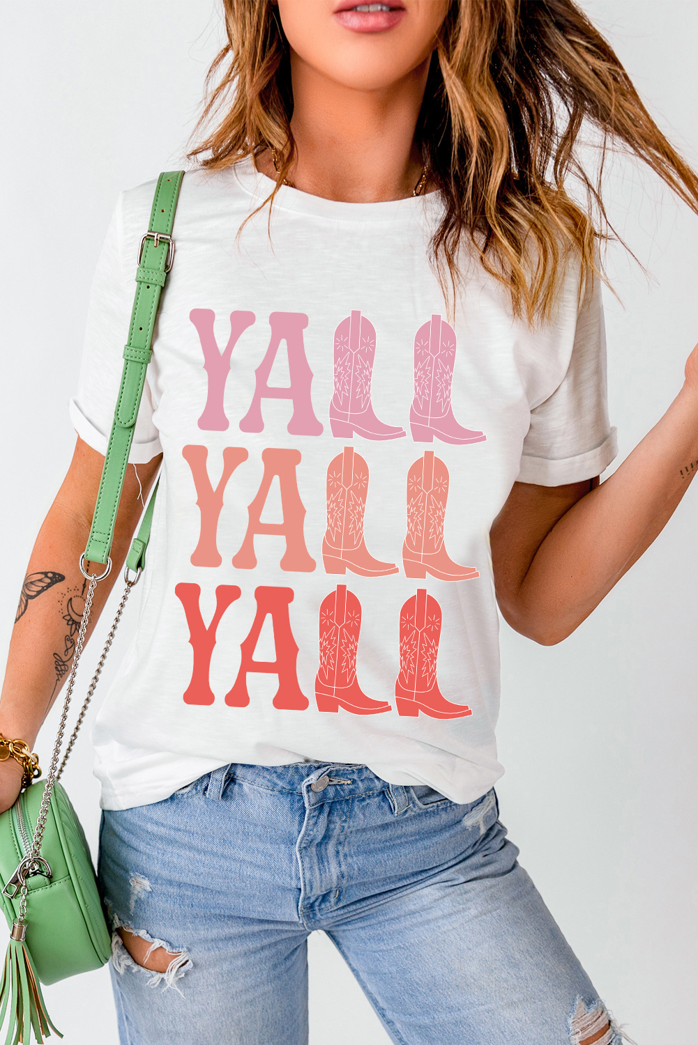 Add a touch of Western charm to your casual wardrobe with this Women's White Y'ALL Cowboy Boots Graphic Crewneck T-Shirt. The classic crewneck design and shift fit make it a comfortable and versatile option for all-day wear. The playful Y'ALL cowboy boots graphic adds a bold and fun statement to the tee, perfect for fans of Western style. Made from a blend of 62% polyester, 32% cotton, and 6% elastane, this t-shirt offers a soft and stretchy feel for maximum comfort. The white color and short sleeves make it suitable for summer, while the casual Western style adds a touch of laid-back charm to your outfit. Pair it with your favorite casual bottoms for a relaxed and stylish look. This graphic t-shirt is perfect for those who appreciate a hint of the West in their fashion. - Detail View 9 Add a touch of Western charm to your casual wardrobe with this Women's White Y'ALL Cowboy Boots Graphic Crewneck T-Shirt. The classic crewneck design and shift fit make it a comfortable and versatile option for all-day wear. The playful Y'ALL cowboy boots graphic adds a bold and fun statement to the tee, perfect for fans of Western style. Made from a blend of 62% polyester, 32% cotton, and 6% elastane, this t-shirt offers a soft and stretchy feel for maximum comfort. The white color and short sleeves make it suitable for summer, while the casual Western style adds a touch of laid-back charm to your outfit. Pair it with your favorite casual bottoms for a relaxed and stylish look. This graphic t-shirt is perfect for those who appreciate a hint of the West in their fashion. - Detail View 9