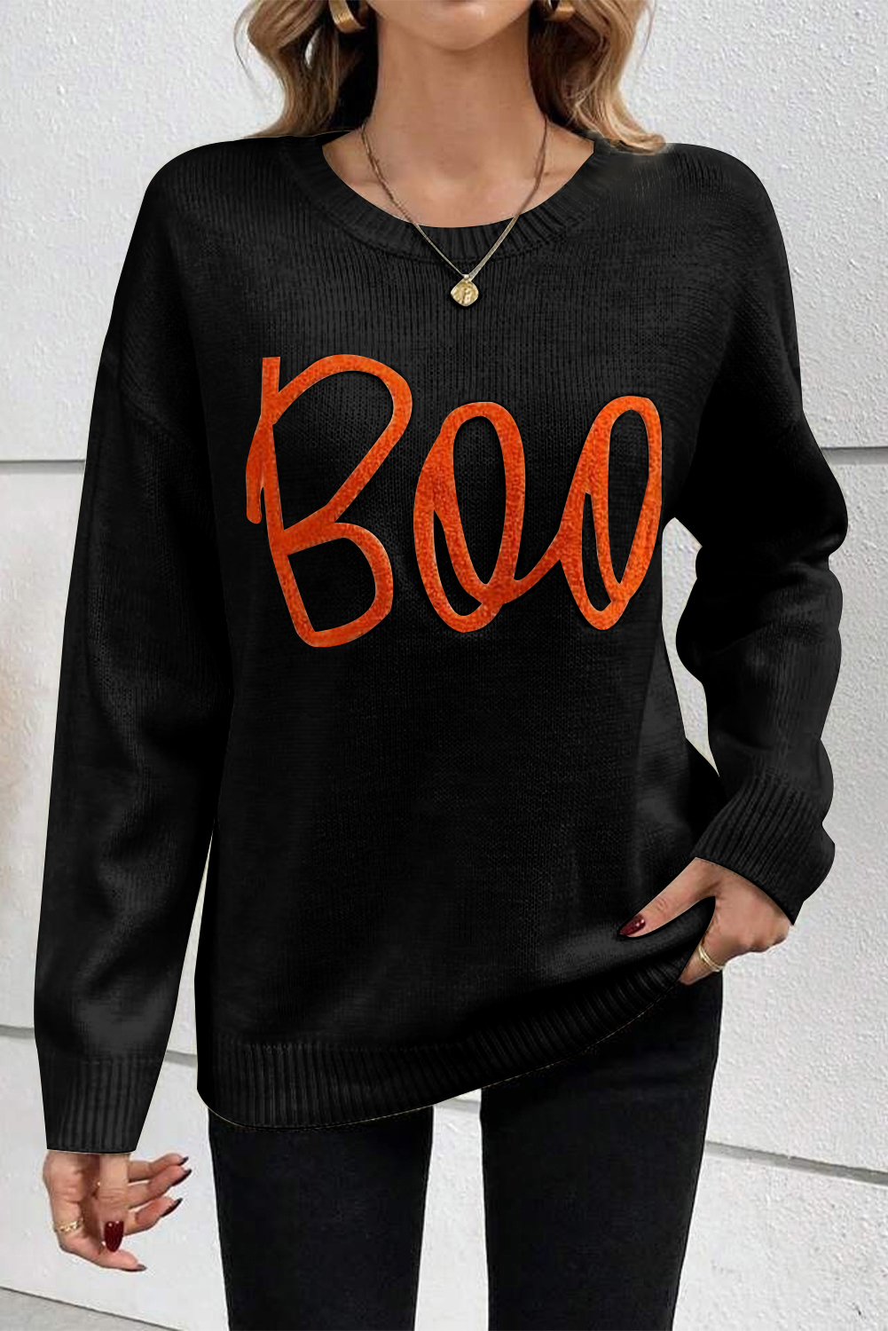 Stay stylish and cozy with this Women's Black Boo Knitted Long Sleeve Sweater with Ribbed Edge. The playful Boo pattern adds a fun and trendy touch to the classic crew neck design. The ribbed trim detailing adds texture and interest to the relaxed fit, making it perfect for casual daily wear. The sweater's loose design strikes the perfect balance between chic and comfortable, making it a great addition to your autumn wardrobe. Pair it with jeans and sneakers for a relaxed weekend look or dress it up with a skirt for a more polished ensemble. This sweater is a must-have for your fall and autumn wardrobe, featuring a cozy fit and a fun touch of Halloween charm. - Detail View 4 Stay stylish and cozy with this Women's Black Boo Knitted Long Sleeve Sweater with Ribbed Edge. The playful Boo pattern adds a fun and trendy touch to the classic crew neck design. The ribbed trim detailing adds texture and interest to the relaxed fit, making it perfect for casual daily wear. The sweater's loose design strikes the perfect balance between chic and comfortable, making it a great addition to your autumn wardrobe. Pair it with jeans and sneakers for a relaxed weekend look or dress it up with a skirt for a more polished ensemble. This sweater is a must-have for your fall and autumn wardrobe, featuring a cozy fit and a fun touch of Halloween charm. - Detail View 4