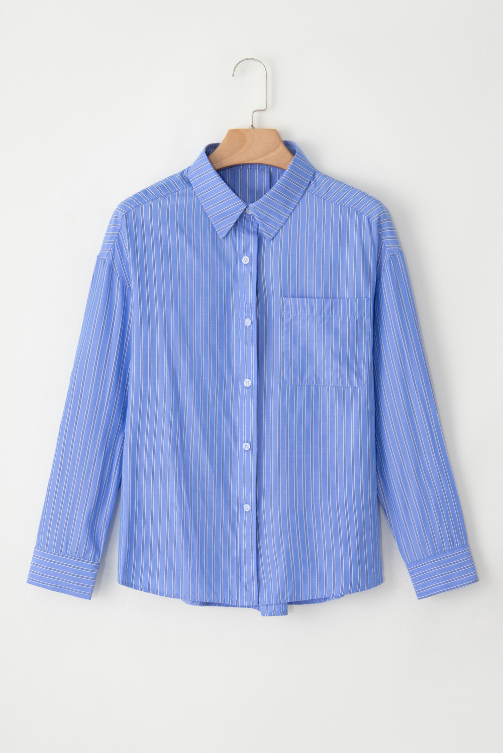 Add a touch of sophistication to your daily wear with this Women's Blue Stripe Oversized Button Up Casual Tunic Shirt. The long sleeves and shift silhouette provide coverage and a relaxed fit, making it perfect for casual gatherings, work, or running errands. The stylish striped pattern adds a classic and trendy twist to your outfit, while the button-up front adds a touch of elegance. Made from a soft blend of 60% polyester and 40% viscose, this shirt is comfortable and easy to care for. Paired with jeans, shorts, or skirts, this shirt is a versatile and chic addition to your wardrobe. Perfect for daily wear, this shirt is a must-have for any fashion enthusiast seeking a stylish and comfortable piece. - Detail View 4 Add a touch of sophistication to your daily wear with this Women's Blue Stripe Oversized Button Up Casual Tunic Shirt. The long sleeves and shift silhouette provide coverage and a relaxed fit, making it perfect for casual gatherings, work, or running errands. The stylish striped pattern adds a classic and trendy twist to your outfit, while the button-up front adds a touch of elegance. Made from a soft blend of 60% polyester and 40% viscose, this shirt is comfortable and easy to care for. Paired with jeans, shorts, or skirts, this shirt is a versatile and chic addition to your wardrobe. Perfect for daily wear, this shirt is a must-have for any fashion enthusiast seeking a stylish and comfortable piece. - Detail View 4