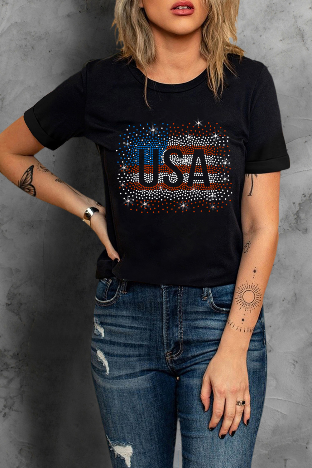 Make a statement with this Women's Stylish Black Rhinestone USA Flag Graphic T-Shirt. The sparkling rhinestones on the America flag graphic add a glamorous touch to your outfit, perfect for elevating your casual look. With a versatile crew neck and short sleeves, this tee is ideal for pairing with jeans or denim shorts for a trendy ensemble. Crafted from a blend of 62% polyester, 32% cotton, and 6% elastane, this tee offers a comfortable and stylish wear during the summer season. The black color adds a chic and edgy vibe to your outfit, making it a must-have piece for your wardrobe. Embrace your patriotic spirit with this eye-catching graphic tee and stand out from the crowd. - Detail View 4 Make a statement with this Women's Stylish Black Rhinestone USA Flag Graphic T-Shirt. The sparkling rhinestones on the America flag graphic add a glamorous touch to your outfit, perfect for elevating your casual look. With a versatile crew neck and short sleeves, this tee is ideal for pairing with jeans or denim shorts for a trendy ensemble. Crafted from a blend of 62% polyester, 32% cotton, and 6% elastane, this tee offers a comfortable and stylish wear during the summer season. The black color adds a chic and edgy vibe to your outfit, making it a must-have piece for your wardrobe. Embrace your patriotic spirit with this eye-catching graphic tee and stand out from the crowd. - Detail View 4