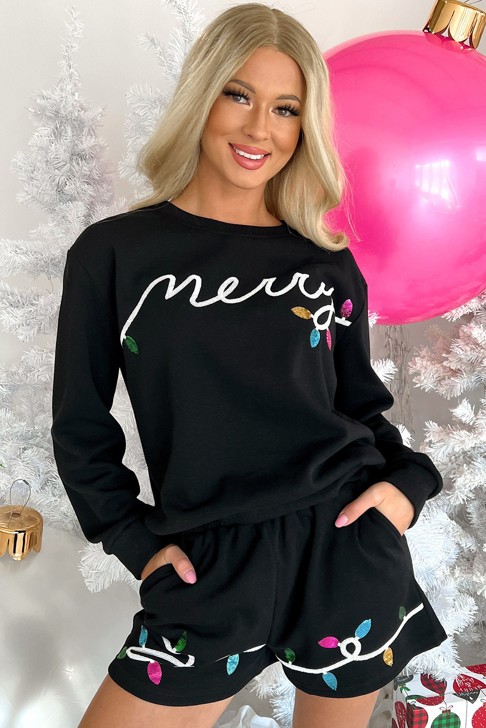 Add a festive touch to your holiday season with this Women's Black Sequin Merry Graphic Pullover and Shorts Outfit. The eye-catching sequined pattern elevates your look to glamorous and celebratory, while the two-piece set provides easy coordination and versatile styling options. The long sleeves keep you warm and cozy during cooler seasons, and the high-waisted shorts strike the perfect balance between chic and casual. This comfortable and stylish outfit is perfect for outdoor gatherings, daily wear, or vacationing. The sequins add a touch of whimsy and fun, making this set a must-have for any Christmas lover. - Detail View 4 Add a festive touch to your holiday season with this Women's Black Sequin Merry Graphic Pullover and Shorts Outfit. The eye-catching sequined pattern elevates your look to glamorous and celebratory, while the two-piece set provides easy coordination and versatile styling options. The long sleeves keep you warm and cozy during cooler seasons, and the high-waisted shorts strike the perfect balance between chic and casual. This comfortable and stylish outfit is perfect for outdoor gatherings, daily wear, or vacationing. The sequins add a touch of whimsy and fun, making this set a must-have for any Christmas lover. - Detail View 4