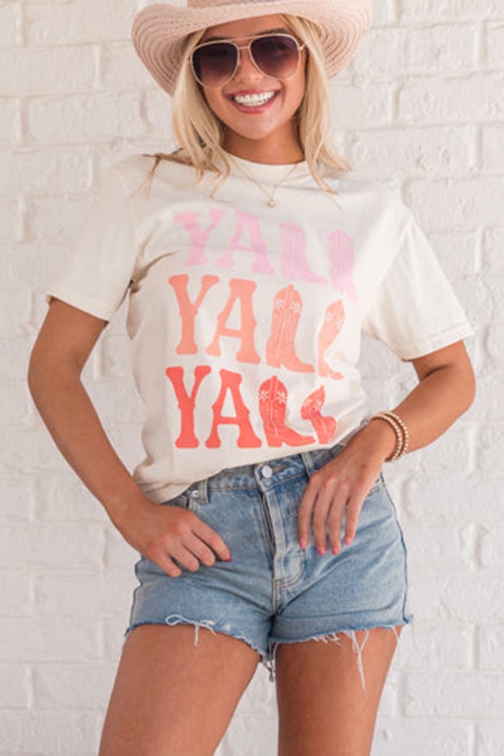 Add a touch of Western charm to your casual wardrobe with this Women's White Y'ALL Cowboy Boots Graphic Crewneck T-Shirt. The classic crewneck design and shift fit make it a comfortable and versatile option for all-day wear. The playful Y'ALL cowboy boots graphic adds a bold and fun statement to the tee, perfect for fans of Western style. Made from a blend of 62% polyester, 32% cotton, and 6% elastane, this t-shirt offers a soft and stretchy feel for maximum comfort. The white color and short sleeves make it suitable for summer, while the casual Western style adds a touch of laid-back charm to your outfit. Pair it with your favorite casual bottoms for a relaxed and stylish look. This graphic t-shirt is perfect for those who appreciate a hint of the West in their fashion. - Detail View 4 Add a touch of Western charm to your casual wardrobe with this Women's White Y'ALL Cowboy Boots Graphic Crewneck T-Shirt. The classic crewneck design and shift fit make it a comfortable and versatile option for all-day wear. The playful Y'ALL cowboy boots graphic adds a bold and fun statement to the tee, perfect for fans of Western style. Made from a blend of 62% polyester, 32% cotton, and 6% elastane, this t-shirt offers a soft and stretchy feel for maximum comfort. The white color and short sleeves make it suitable for summer, while the casual Western style adds a touch of laid-back charm to your outfit. Pair it with your favorite casual bottoms for a relaxed and stylish look. This graphic t-shirt is perfect for those who appreciate a hint of the West in their fashion. - Detail View 4