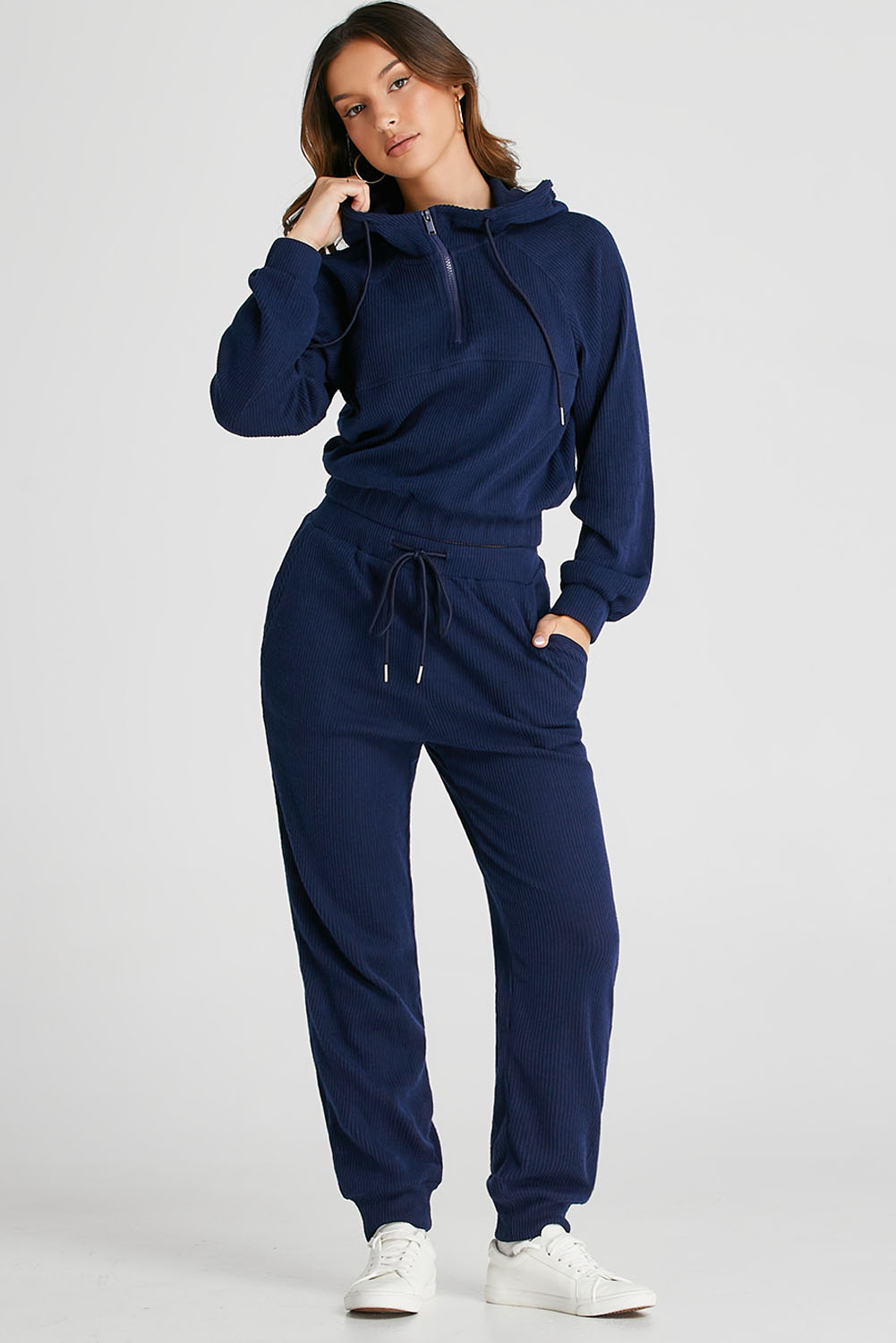 Elevate your activewear collection with this Women's Navy Blue Ribbed Knit Cropped Hoodie and Drawstring Joggers Set. The set includes a cropped hoodie and joggers, offering a coordinated and trendy outfit for your active lifestyle. The stylish ribbed knit design adds a textured look, while the adjustable drawstring on the waist ensures a customized and comfortable fit. Crafted from premium quality fabric, this set provides ultra comfort during workout sessions or casual wear. The hoodie features a hooded neckline and long sleeves, while the joggers come with a high waist and convenient pockets. Versatile and practical, this activewear set is perfect for both workouts and everyday activities. Stay chic and comfortable with this fashionable set in classic navy blue color. - Detail View 4 Elevate your activewear collection with this Women's Navy Blue Ribbed Knit Cropped Hoodie and Drawstring Joggers Set. The set includes a cropped hoodie and joggers, offering a coordinated and trendy outfit for your active lifestyle. The stylish ribbed knit design adds a textured look, while the adjustable drawstring on the waist ensures a customized and comfortable fit. Crafted from premium quality fabric, this set provides ultra comfort during workout sessions or casual wear. The hoodie features a hooded neckline and long sleeves, while the joggers come with a high waist and convenient pockets. Versatile and practical, this activewear set is perfect for both workouts and everyday activities. Stay chic and comfortable with this fashionable set in classic navy blue color. - Detail View 4