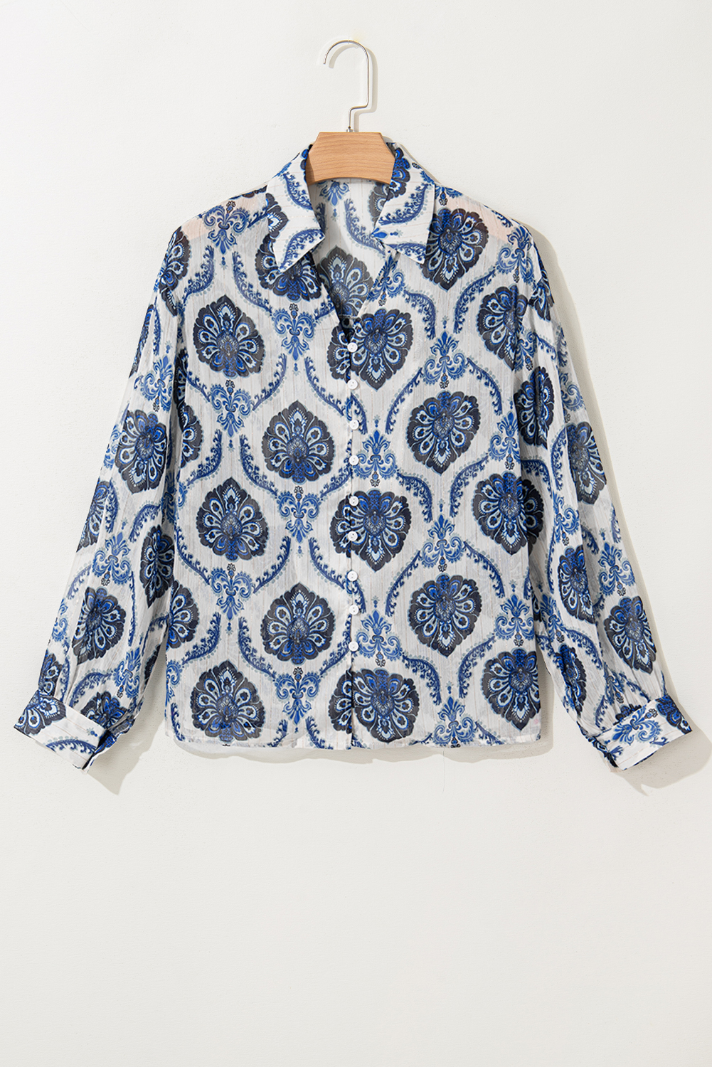 Add a touch of global flair to your wardrobe with this Women's Bohemian Blue Tribal Pattern Long Sleeve Shirt. The buttoned front design allows for easy wear and style customization, while the eye-catching tribal pattern is rich in cultural artistry. The loose fit silhouette and long sleeves exude a laid-back, bohemian vibe, perfect for daily wear. Pair it with simple bottoms and flats for a trendy outlook, or dress it up with more statement pieces for a stylish evening look. This exotic-inspired shirt is a must-have for your wardrobe, adding a touch of elegance and sophistication. - Detail View 9 Add a touch of global flair to your wardrobe with this Women's Bohemian Blue Tribal Pattern Long Sleeve Shirt. The buttoned front design allows for easy wear and style customization, while the eye-catching tribal pattern is rich in cultural artistry. The loose fit silhouette and long sleeves exude a laid-back, bohemian vibe, perfect for daily wear. Pair it with simple bottoms and flats for a trendy outlook, or dress it up with more statement pieces for a stylish evening look. This exotic-inspired shirt is a must-have for your wardrobe, adding a touch of elegance and sophistication. - Detail View 9