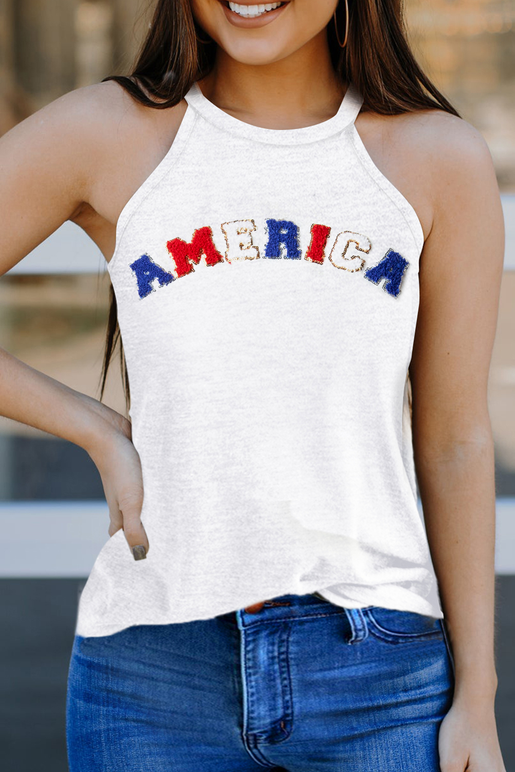 Elevate your casual style with this White Chenille AMERICA Graphic Tank Top for women. Featuring a chenille graphic design with glitter frames, this tank top is made of soft lightweight fabric in a comfortable loose fit. The simple fashion design is well received by all ages, making it a versatile addition to your wardrobe. The sleeveless silhouette and round neck neckline offer a modern and chic look, suitable for daily wear. Made from 95% polyester and 5% elastane, this tank top ensures durability and breathability, perfect for the summer season. Whether you're heading to a casual outing or a relaxed day out, this graphic tank top is a stylish choice for modern women. Pair it with your favorite jeans or shorts for a laid-back and trendy ensemble. - Detail View 4 Elevate your casual style with this White Chenille AMERICA Graphic Tank Top for women. Featuring a chenille graphic design with glitter frames, this tank top is made of soft lightweight fabric in a comfortable loose fit. The simple fashion design is well received by all ages, making it a versatile addition to your wardrobe. The sleeveless silhouette and round neck neckline offer a modern and chic look, suitable for daily wear. Made from 95% polyester and 5% elastane, this tank top ensures durability and breathability, perfect for the summer season. Whether you're heading to a casual outing or a relaxed day out, this graphic tank top is a stylish choice for modern women. Pair it with your favorite jeans or shorts for a laid-back and trendy ensemble. - Detail View 4