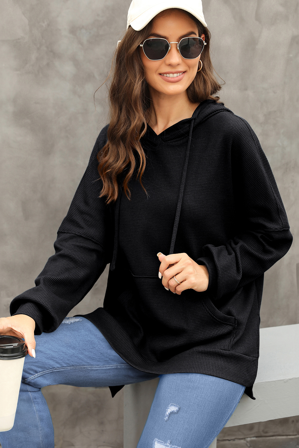 Elevate your casual style with this Women's Black Waffle Knit Fleece Lined High-Low Oversized Hoodie. The soft jacquard knit fabric creates a cozy feel, perfect for the colder seasons. The stylish high-low design and oversized fit enhance a casual and slender silhouette, while the outstanding fleece lining provides warmth and comfort. The convenient kangaroo pocket not only offers storage but also adds a decorative element to the hoodie. Made from a blend of 75% polyester and 25% cotton, this hoodie ensures durability and a comfortable fit. The solid black color and hooded neckline make it a versatile addition to your fall and winter wardrobe. Perfect for daily wear, this hoodie is a must-have for staying warm and stylish during the colder months. - Detail View 4 Elevate your casual style with this Women's Black Waffle Knit Fleece Lined High-Low Oversized Hoodie. The soft jacquard knit fabric creates a cozy feel, perfect for the colder seasons. The stylish high-low design and oversized fit enhance a casual and slender silhouette, while the outstanding fleece lining provides warmth and comfort. The convenient kangaroo pocket not only offers storage but also adds a decorative element to the hoodie. Made from a blend of 75% polyester and 25% cotton, this hoodie ensures durability and a comfortable fit. The solid black color and hooded neckline make it a versatile addition to your fall and winter wardrobe. Perfect for daily wear, this hoodie is a must-have for staying warm and stylish during the colder months. - Detail View 4