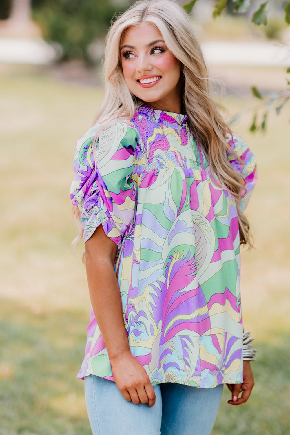 Elevate your casual chic look with this Women's Green Abstract Print Bubble Sleeve Smock Detail Blouse. The unique abstract print adds a modern touch to the blouse, while the bubble sleeves with ruched detailing create a playful and feminine look. The loose fit provides a relaxed and cozy feel, making it perfect for both casual or dressed-up occasions. The smock detail on the neckline adds a touch of sophistication and elegance to the overall design, making it a versatile and easy-to-style wardrobe essential. Made from high-quality 100% cotton material, this blouse ensures comfort and breathability, ideal for the summer season. The short puff sleeves and round neckline complete the stylish and trendy silhouette. Pair it with your favorite jeans or dress it up with a skirt for a fashion-forward ensemble. This green smock blouse is a must-have for your daily wardrobe, offering a perfect blend of style and comfort. - Detail View 4 Elevate your casual chic look with this Women's Green Abstract Print Bubble Sleeve Smock Detail Blouse. The unique abstract print adds a modern touch to the blouse, while the bubble sleeves with ruched detailing create a playful and feminine look. The loose fit provides a relaxed and cozy feel, making it perfect for both casual or dressed-up occasions. The smock detail on the neckline adds a touch of sophistication and elegance to the overall design, making it a versatile and easy-to-style wardrobe essential. Made from high-quality 100% cotton material, this blouse ensures comfort and breathability, ideal for the summer season. The short puff sleeves and round neckline complete the stylish and trendy silhouette. Pair it with your favorite jeans or dress it up with a skirt for a fashion-forward ensemble. This green smock blouse is a must-have for your daily wardrobe, offering a perfect blend of style and comfort. - Detail View 4