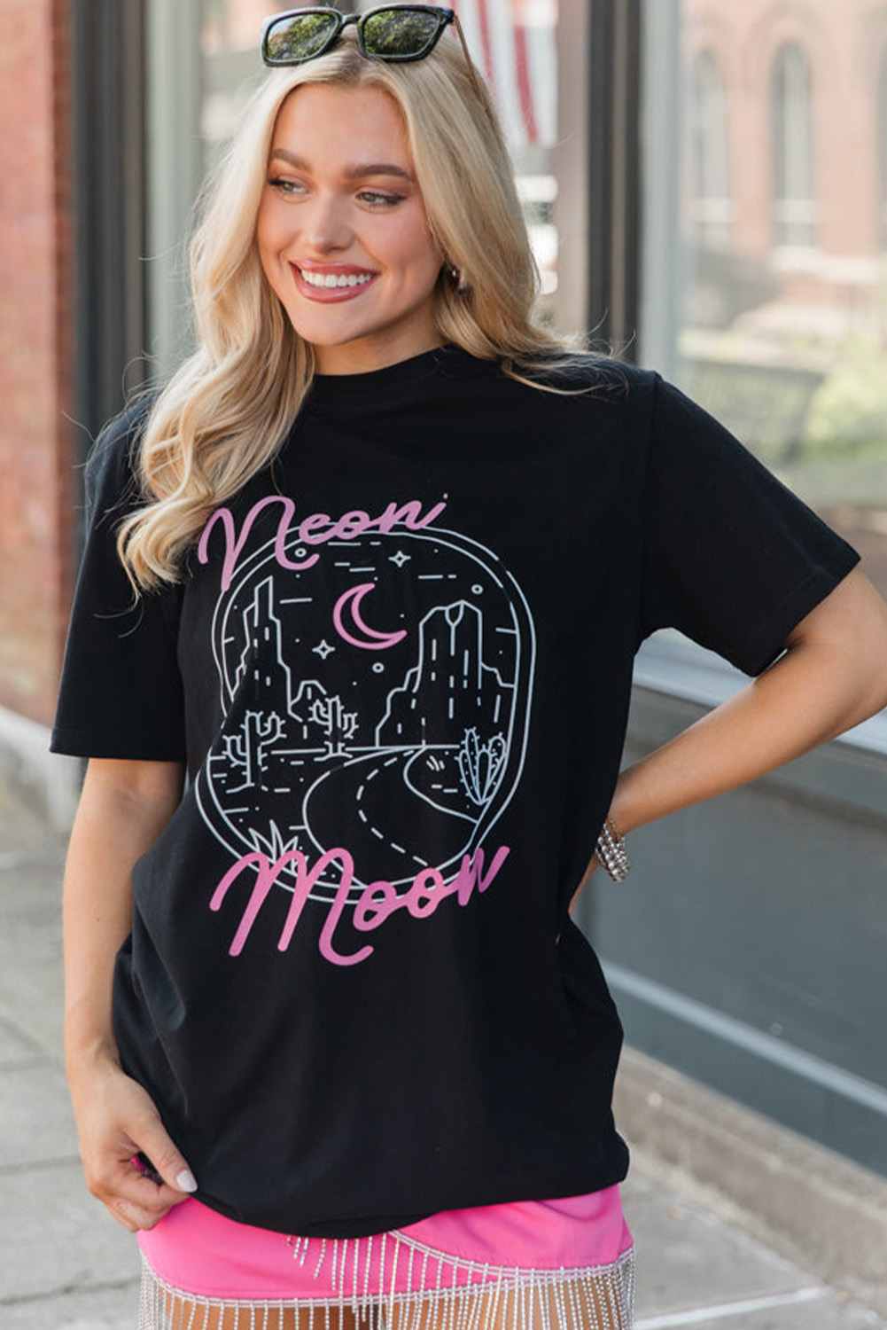 Make a statement with this Women's Black Neon Moon Letter Graphic Short Sleeve Top. The neon moon letter graphic adds a touch of celestial magic to the design, while the delicate desert landscape print brings a unique and trendy touch. The short sleeves and round neck are perfect for warm weather, and can be easily paired with dark denim or leggings to let the graphic take center stage. Graphic tees are versatile and can be dressed up or down for various casual occasions. This top is a must-have for anyone who loves bold and stylish fashion. Made from a comfortable blend of 62% polyester, 32% cotton, and 6% elastane, this graphic tee ensures a smooth and breathable fit. - Detail View 4 Make a statement with this Women's Black Neon Moon Letter Graphic Short Sleeve Top. The neon moon letter graphic adds a touch of celestial magic to the design, while the delicate desert landscape print brings a unique and trendy touch. The short sleeves and round neck are perfect for warm weather, and can be easily paired with dark denim or leggings to let the graphic take center stage. Graphic tees are versatile and can be dressed up or down for various casual occasions. This top is a must-have for anyone who loves bold and stylish fashion. Made from a comfortable blend of 62% polyester, 32% cotton, and 6% elastane, this graphic tee ensures a smooth and breathable fit. - Detail View 4