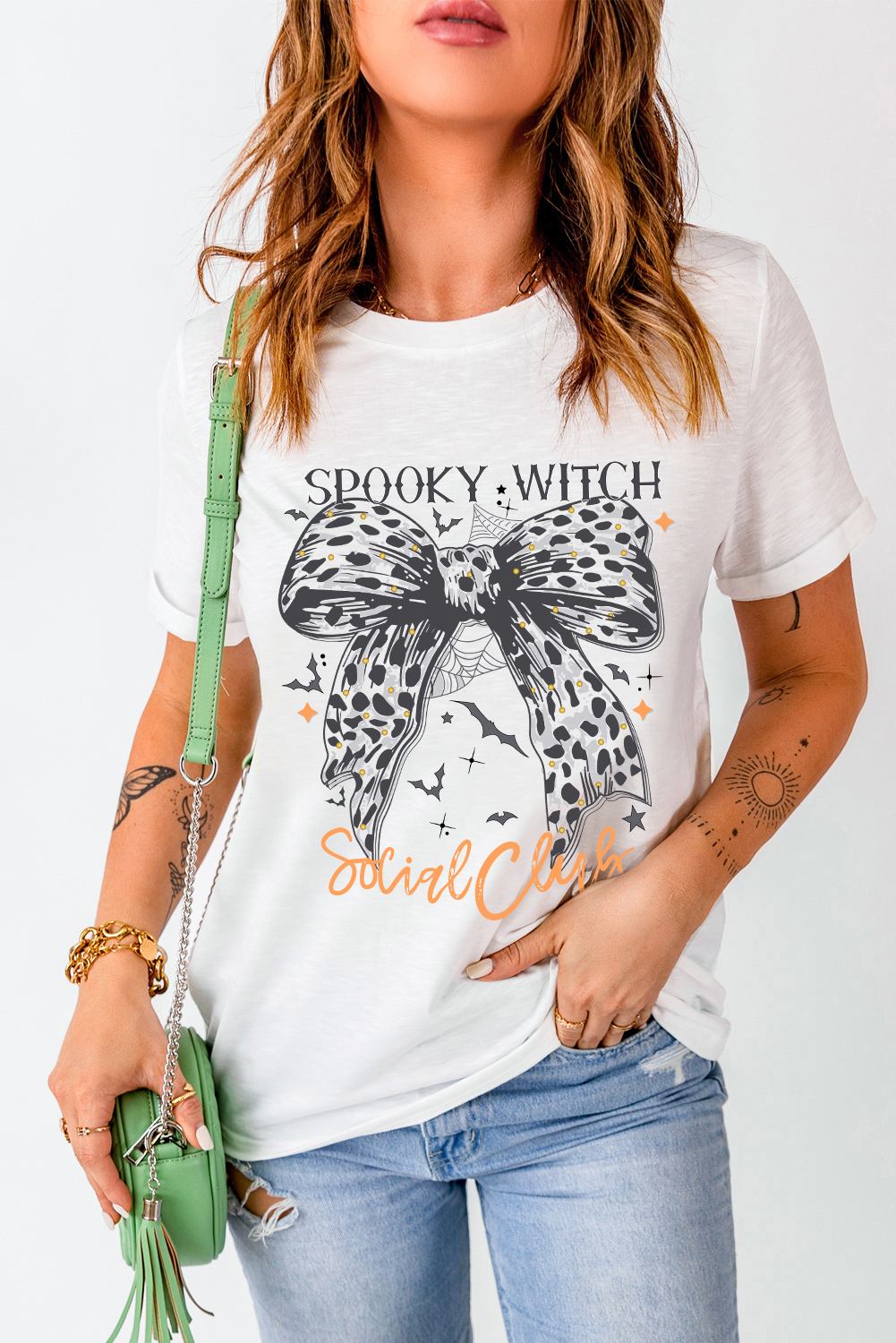 Get into the spooky spirit with this Women's White Spooky Witch Leopard Bowknot Bat Graphic Halloween T-Shirt. A fun and festive choice for the Halloween season, this graphic tee features a playful leopard bowknot print and a bat graphic, adding a touch of Halloween flair to your outfit. The cozy blend of 62% polyester, 32% cotton, and 6% elastane ensures a comfortable wear for all your Halloween celebrations. Pair this tee with leggings or jeans for a casual, Halloween-ready outfit that is perfect for trick-or-treating or themed parties. The round neck and short sleeves make it a versatile and easy-to-wear option for daily wear and special Halloween events. Embrace the Halloween spirit with this stylish and fun graphic t-shirt! - Detail View 4 Get into the spooky spirit with this Women's White Spooky Witch Leopard Bowknot Bat Graphic Halloween T-Shirt. A fun and festive choice for the Halloween season, this graphic tee features a playful leopard bowknot print and a bat graphic, adding a touch of Halloween flair to your outfit. The cozy blend of 62% polyester, 32% cotton, and 6% elastane ensures a comfortable wear for all your Halloween celebrations. Pair this tee with leggings or jeans for a casual, Halloween-ready outfit that is perfect for trick-or-treating or themed parties. The round neck and short sleeves make it a versatile and easy-to-wear option for daily wear and special Halloween events. Embrace the Halloween spirit with this stylish and fun graphic t-shirt! - Detail View 4