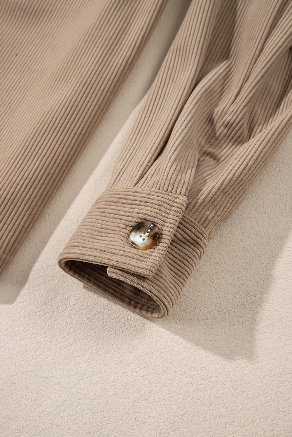 Elevate your winter wardrobe with this Women's Pale Khaki Hooded Drawstring Corduroy Shacket. The shacket features a regular fit with a hood design and drawstring details along the neckline, offering both style and functionality. The button-up front and two chest pockets add a classic and fashionable touch to the shacket. Made from premium 100% polyester corduroy, this shacket is durable and comfortable, making it suitable for all kinds of daily occasions. The solid pale khaki color adds a timeless and versatile appeal to the shacket. Perfect for the winter season, this hooded shacket is designed to keep you warm and stylish. Its chic style and design make it a popular choice among fashion-conscious individuals. Embrace the cozy and trendy vibe with this must-have women's shacket. - Detail View 9 Elevate your winter wardrobe with this Women's Pale Khaki Hooded Drawstring Corduroy Shacket. The shacket features a regular fit with a hood design and drawstring details along the neckline, offering both style and functionality. The button-up front and two chest pockets add a classic and fashionable touch to the shacket. Made from premium 100% polyester corduroy, this shacket is durable and comfortable, making it suitable for all kinds of daily occasions. The solid pale khaki color adds a timeless and versatile appeal to the shacket. Perfect for the winter season, this hooded shacket is designed to keep you warm and stylish. Its chic style and design make it a popular choice among fashion-conscious individuals. Embrace the cozy and trendy vibe with this must-have women's shacket. - Detail View 9