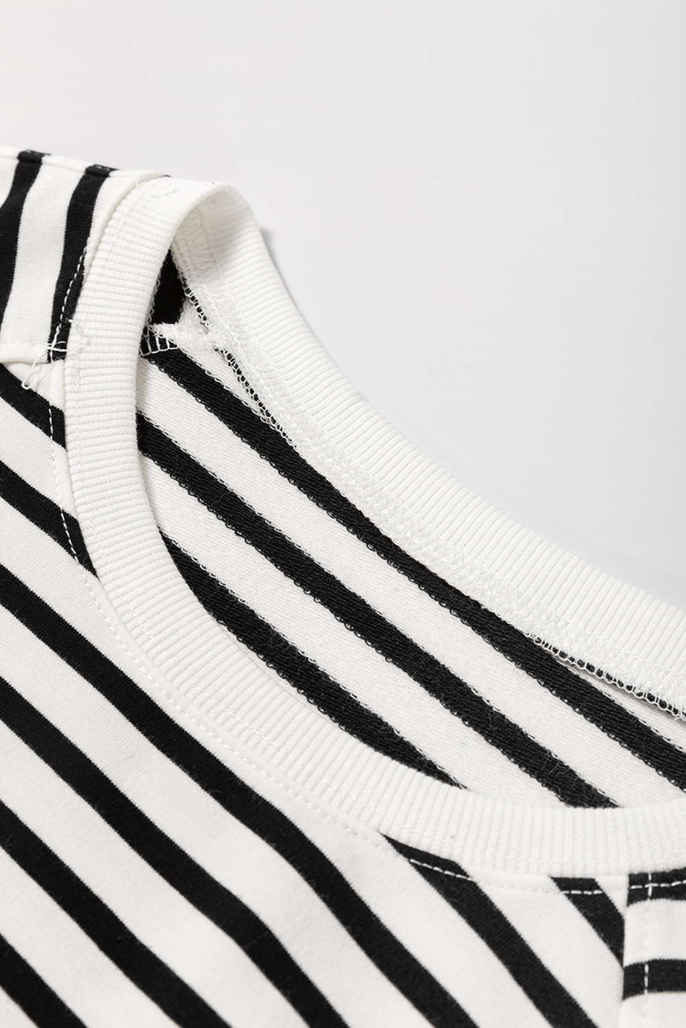Elevate your casual wear with this Women's Black Stripe Raglan Sleeve Loose Fit Sweatshirt with Side Slits. The classic striped pattern is both timeless and trendy, featuring a chic crew neckline, raglan sleeves, and a loose fit style. The side slits add a modern and edgy touch, enhancing the sweatshirt's casual appeal. Perfect for everyday wear, this sweatshirt pairs well with casual jeans and sweatpants. Made from a soft and breathable blend of 95% cotton and 5% elastane, it offers both style and comfort. This sweatshirt is a great addition to your wardrobe, suitable for daily wear and offering a relaxed and stylish look. - Detail View 9 Elevate your casual wear with this Women's Black Stripe Raglan Sleeve Loose Fit Sweatshirt with Side Slits. The classic striped pattern is both timeless and trendy, featuring a chic crew neckline, raglan sleeves, and a loose fit style. The side slits add a modern and edgy touch, enhancing the sweatshirt's casual appeal. Perfect for everyday wear, this sweatshirt pairs well with casual jeans and sweatpants. Made from a soft and breathable blend of 95% cotton and 5% elastane, it offers both style and comfort. This sweatshirt is a great addition to your wardrobe, suitable for daily wear and offering a relaxed and stylish look. - Detail View 9