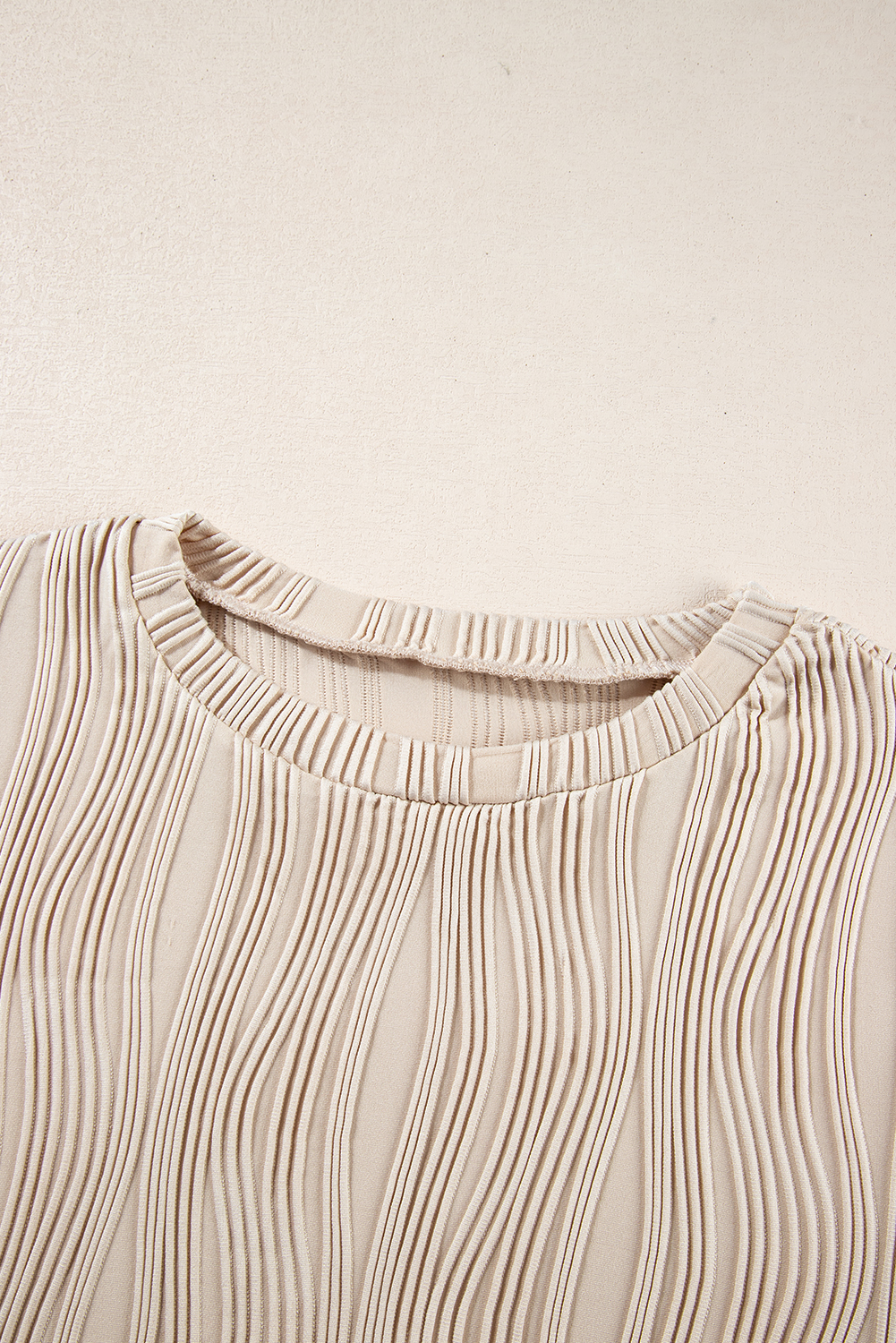 Elevate your casual wardrobe with this Women's Apricot Textured Wavy Round Neck Long Sleeve Top. The intricate wavy fabric adds a distinctive tactile appeal to the classic round neck design. Made from a premium blend of 91% polyester and 9% elastane, this top ensures comfort and durability. The timeless and concise style, along with the solid apricot color, makes it versatile to style and complements any outfit. The long sleeves make it perfect for the fall and autumn seasons, pairing well with fashionable jeans and pants. Whether for a casual day out or a work setting, this top is a must-have addition to your wardrobe, offering both style and comfort. - Detail View 9 Elevate your casual wardrobe with this Women's Apricot Textured Wavy Round Neck Long Sleeve Top. The intricate wavy fabric adds a distinctive tactile appeal to the classic round neck design. Made from a premium blend of 91% polyester and 9% elastane, this top ensures comfort and durability. The timeless and concise style, along with the solid apricot color, makes it versatile to style and complements any outfit. The long sleeves make it perfect for the fall and autumn seasons, pairing well with fashionable jeans and pants. Whether for a casual day out or a work setting, this top is a must-have addition to your wardrobe, offering both style and comfort. - Detail View 9