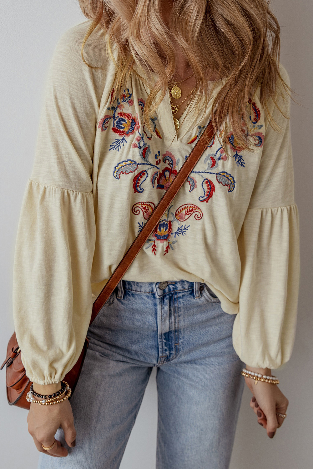 Add a touch of bohemian elegance to your wardrobe with this Women's Apricot Paisley Floral Embroidered Notch V Neck Blouse. The intricate paisley floral embroidery adorns the blouse, giving it an artisanal charm and sophistication. The stylish notch V neck design catches the eye, while the relaxed fit and flowy cut ensure comfort and ease of movement. This blouse is perfect for adding a feminine flair to your daily outfits. Pair it with distressed denim jeans for a chic and stylish look. Catch the latest early fall fashion trend with this beautiful blouse, featuring delicate embroidery details and a unique paisley floral pattern. - Detail View 4 Add a touch of bohemian elegance to your wardrobe with this Women's Apricot Paisley Floral Embroidered Notch V Neck Blouse. The intricate paisley floral embroidery adorns the blouse, giving it an artisanal charm and sophistication. The stylish notch V neck design catches the eye, while the relaxed fit and flowy cut ensure comfort and ease of movement. This blouse is perfect for adding a feminine flair to your daily outfits. Pair it with distressed denim jeans for a chic and stylish look. Catch the latest early fall fashion trend with this beautiful blouse, featuring delicate embroidery details and a unique paisley floral pattern. - Detail View 4
