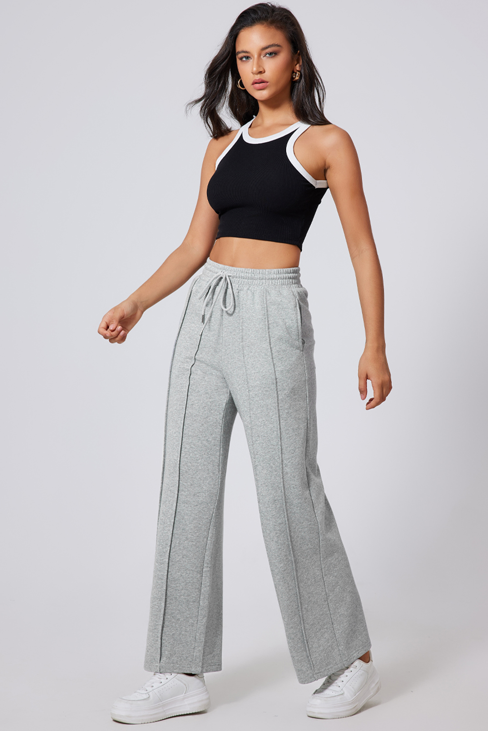 Elevate your athleisure style with these Women's Gray Seamed Drawstring High Waist Wide Leg Sweatpants. The stylish seamed detailing adds a trendy touch to the design, while the adjustable drawstring high waist offers a customized and comfortable fit. The wide leg silhouette provides a relaxed and comfortable feel, making these sweatpants perfect for daily activities and exercises. Made from a premium blend of 65% polyester and 35% cotton, these sweatpants ensure durability and breathability. Available in a versatile gray color, they can easily complement any style and outfit. Whether you're hitting the gym, going for a run, or simply lounging at home, these sweatpants are a must-have addition to your activewear collection. - Detail View 9 Elevate your athleisure style with these Women's Gray Seamed Drawstring High Waist Wide Leg Sweatpants. The stylish seamed detailing adds a trendy touch to the design, while the adjustable drawstring high waist offers a customized and comfortable fit. The wide leg silhouette provides a relaxed and comfortable feel, making these sweatpants perfect for daily activities and exercises. Made from a premium blend of 65% polyester and 35% cotton, these sweatpants ensure durability and breathability. Available in a versatile gray color, they can easily complement any style and outfit. Whether you're hitting the gym, going for a run, or simply lounging at home, these sweatpants are a must-have addition to your activewear collection. - Detail View 9