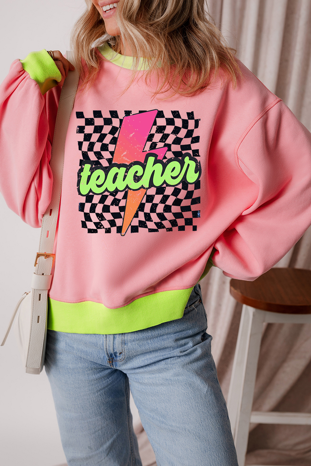 Make a statement with this Women's Pink Teacher Lightning Checkered Print Color Block Sweatshirt. The drop shoulder design creates a comfortable and stylish silhouette, while the bold 'Teacher' lettering adds a smart touch. The striking lightning graphic adds a dynamic element, and the trendy color block design makes it perfect for a modern look. This sweatshirt is the perfect combination of chic and casual, making it suitable for daily wear. The 50% polyester and 50% cotton blend ensures durability and comfort. Pair it with your favorite jeans or leggings for a trendy outfit. - Detail View 4 Make a statement with this Women's Pink Teacher Lightning Checkered Print Color Block Sweatshirt. The drop shoulder design creates a comfortable and stylish silhouette, while the bold 'Teacher' lettering adds a smart touch. The striking lightning graphic adds a dynamic element, and the trendy color block design makes it perfect for a modern look. This sweatshirt is the perfect combination of chic and casual, making it suitable for daily wear. The 50% polyester and 50% cotton blend ensures durability and comfort. Pair it with your favorite jeans or leggings for a trendy outfit. - Detail View 4