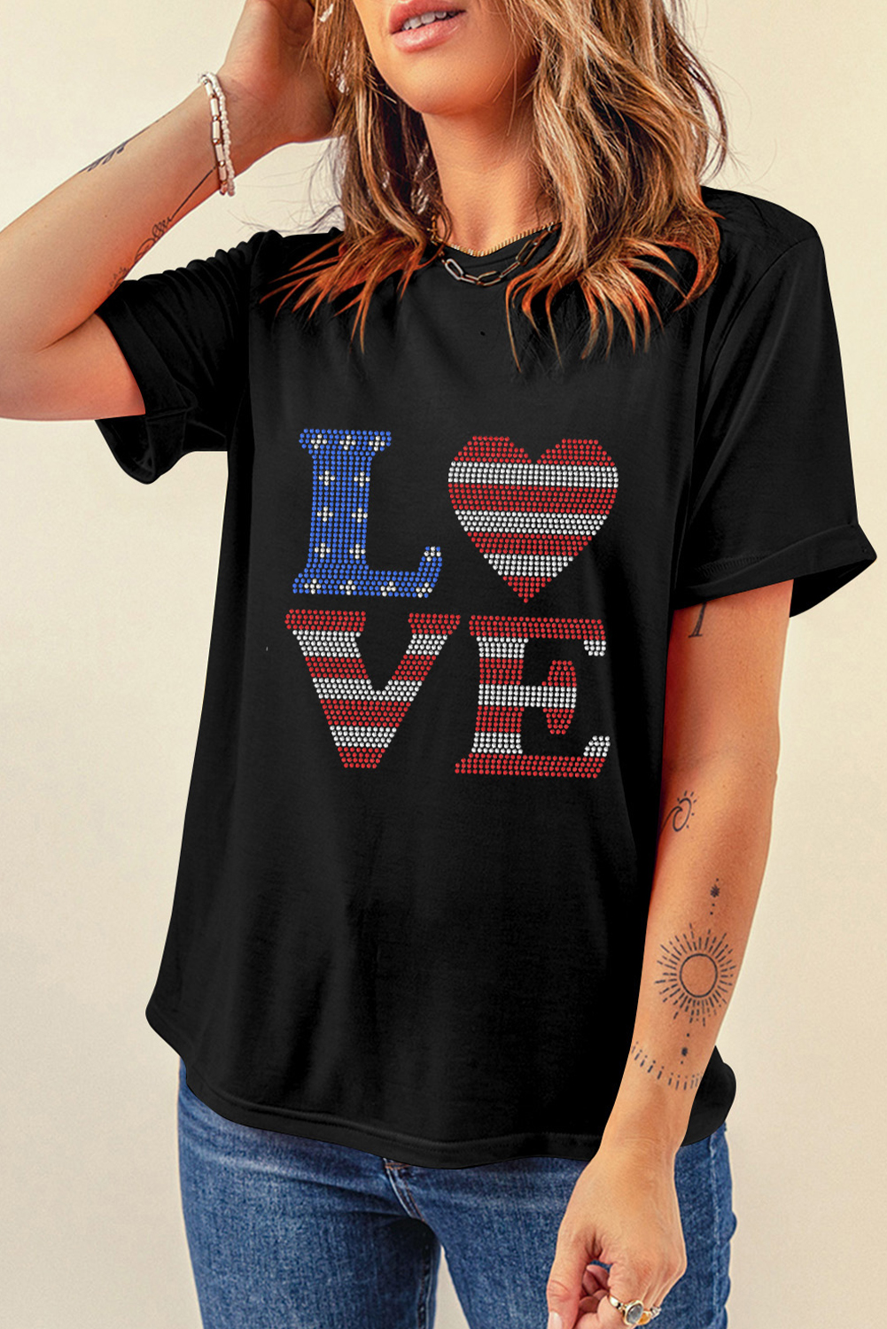 Show your patriotic spirit with style and flair with this Women's Black Rhinestone USA Flag Stripes and Stars LOVE Graphic T-Shirt. The bold and playful design features a patriotic American flag motif with sparkling rhinestones adding a touch of glamour and shine. The 'LOVE' lettering adds a message of unity and positivity. This casual graphic tee is perfect for daily wear and a great way to represent your love for your country. Made from 62% polyester, 32% cotton, and 6% elastane, this tee provides a comfortable fit with a relaxed style. Whether you're running errands, attending a casual gathering, or simply lounging around, this graphic tee is a great choice. Pair it with distressed denim jeans and sneakers for a funky and stylish outfit. This fun and playful graphic tee is a must-have addition to your wardrobe, featuring a variety of options to match your unique style. - Detail View 4 Show your patriotic spirit with style and flair with this Women's Black Rhinestone USA Flag Stripes and Stars LOVE Graphic T-Shirt. The bold and playful design features a patriotic American flag motif with sparkling rhinestones adding a touch of glamour and shine. The 'LOVE' lettering adds a message of unity and positivity. This casual graphic tee is perfect for daily wear and a great way to represent your love for your country. Made from 62% polyester, 32% cotton, and 6% elastane, this tee provides a comfortable fit with a relaxed style. Whether you're running errands, attending a casual gathering, or simply lounging around, this graphic tee is a great choice. Pair it with distressed denim jeans and sneakers for a funky and stylish outfit. This fun and playful graphic tee is a must-have addition to your wardrobe, featuring a variety of options to match your unique style. - Detail View 4