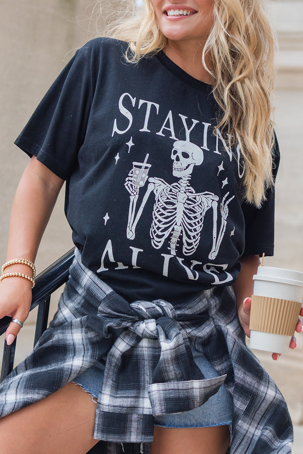 Add a touch of edginess and playfulness to your wardrobe with this Women's Black STAYING ALIVE Funny Skeleton Print Round Neck T-Shirt. The classic crew neck design provides a comfortable and casual fit, while the short sleeves offer a cool and relaxed style. The unique skeleton print with the STAYING ALIVE slogan is perfect for a fun and quirky touch. This graphic tee is ideal for enhancing your fashion game with its diverse and edgy options. It's a must-have for Halloween and everyday wear, making it a great addition to your wardrobe. - Detail View 4 Add a touch of edginess and playfulness to your wardrobe with this Women's Black STAYING ALIVE Funny Skeleton Print Round Neck T-Shirt. The classic crew neck design provides a comfortable and casual fit, while the short sleeves offer a cool and relaxed style. The unique skeleton print with the STAYING ALIVE slogan is perfect for a fun and quirky touch. This graphic tee is ideal for enhancing your fashion game with its diverse and edgy options. It's a must-have for Halloween and everyday wear, making it a great addition to your wardrobe. - Detail View 4