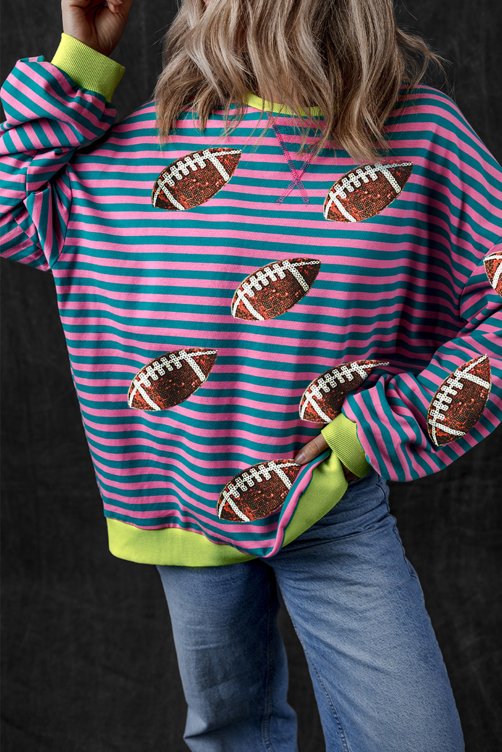 Add a touch of excitement to your game day ensemble with this Women's Green Stripe Sequin Rugby Football Graphic Colorblock Edge Sweatshirt. The striped design combines with dazzling sequins for a unique and eye-catching visual appeal. The color block edges enhance the sweatshirt's sporty vibe, while the rugby football graphic captures the thrill of the game. Made from a comfortable blend of 95% cotton and 5% elastane, this graphic sweatshirt is perfect for staying cozy while watching your favorite sports team play. With its oversized silhouette and round neck, this sweatshirt is designed to keep you comfortable and chic. Pair it with jeans and sneakers for a casual and confident look that's sure to turn heads. - Detail View 4 Add a touch of excitement to your game day ensemble with this Women's Green Stripe Sequin Rugby Football Graphic Colorblock Edge Sweatshirt. The striped design combines with dazzling sequins for a unique and eye-catching visual appeal. The color block edges enhance the sweatshirt's sporty vibe, while the rugby football graphic captures the thrill of the game. Made from a comfortable blend of 95% cotton and 5% elastane, this graphic sweatshirt is perfect for staying cozy while watching your favorite sports team play. With its oversized silhouette and round neck, this sweatshirt is designed to keep you comfortable and chic. Pair it with jeans and sneakers for a casual and confident look that's sure to turn heads. - Detail View 4