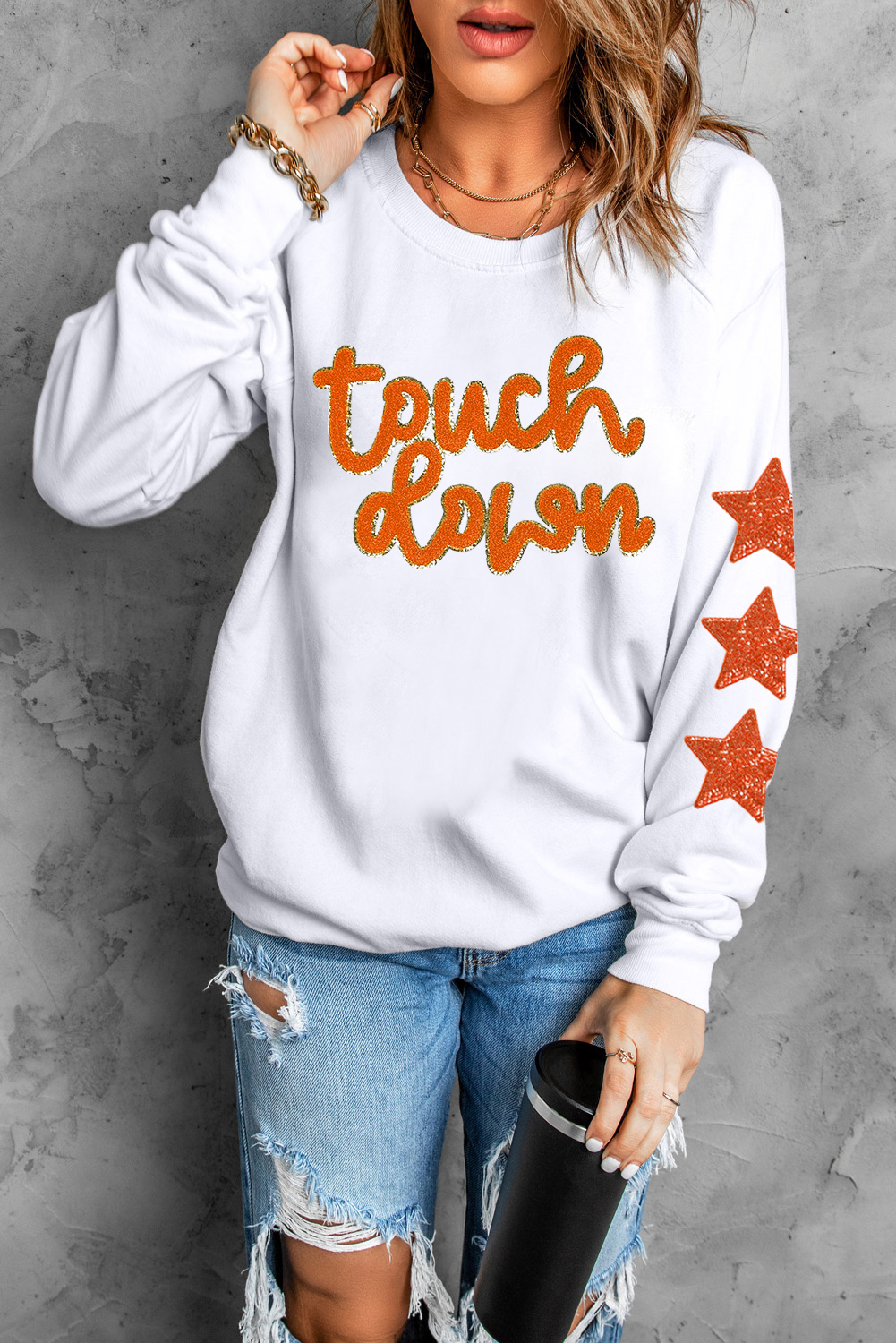 Add a touch of glamour and playfulness to your outfit with this Beige Glittering Touch Down Patched Pattern Star Sleeve Sweatshirt. The dazzling glittering accents and star patterns on the sleeves make this sweatshirt perfect for game day or casual wear. The patched pattern showcases your love for the game, while the round neckline and shift silhouette ensure a comfortable and relaxed fit. Made from a blend of 50% polyester and 50% cotton, this graphic sweatshirt is designed to keep you fashionable during cooler weather. Pair it with your favorite jeans or leggings for a chic and trendy look. This sweatshirt is a must-have addition to your wardrobe, offering both style and warmth. - Detail View 4 Add a touch of glamour and playfulness to your outfit with this Beige Glittering Touch Down Patched Pattern Star Sleeve Sweatshirt. The dazzling glittering accents and star patterns on the sleeves make this sweatshirt perfect for game day or casual wear. The patched pattern showcases your love for the game, while the round neckline and shift silhouette ensure a comfortable and relaxed fit. Made from a blend of 50% polyester and 50% cotton, this graphic sweatshirt is designed to keep you fashionable during cooler weather. Pair it with your favorite jeans or leggings for a chic and trendy look. This sweatshirt is a must-have addition to your wardrobe, offering both style and warmth. - Detail View 4
