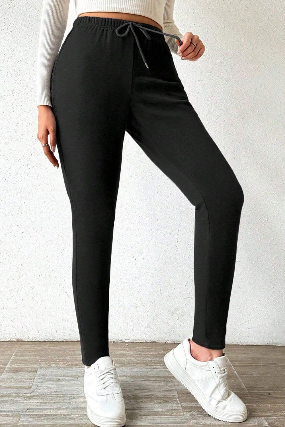 Stay cozy and fashionable with these Women's Black Thermal Lined Drawstring High Waist Leggings. The thermal lining provides extra warmth on chilly days, making them perfect for the winter season. The high waist design with a drawstring offers comfortable tummy control and ensures a flattering fit. Made from a premium blend of 70% polyester, 27% viscose, and 3% elastane, these leggings combine comfort and style effortlessly. The solid black color not only adds a touch of elegance but also creates a slimming effect, making them a versatile and essential addition to your wardrobe. Perfect for daily wear, these leggings offer both comfort and fashion, making them a must-have for the season. - Detail View 4 Stay cozy and fashionable with these Women's Black Thermal Lined Drawstring High Waist Leggings. The thermal lining provides extra warmth on chilly days, making them perfect for the winter season. The high waist design with a drawstring offers comfortable tummy control and ensures a flattering fit. Made from a premium blend of 70% polyester, 27% viscose, and 3% elastane, these leggings combine comfort and style effortlessly. The solid black color not only adds a touch of elegance but also creates a slimming effect, making them a versatile and essential addition to your wardrobe. Perfect for daily wear, these leggings offer both comfort and fashion, making them a must-have for the season. - Detail View 4