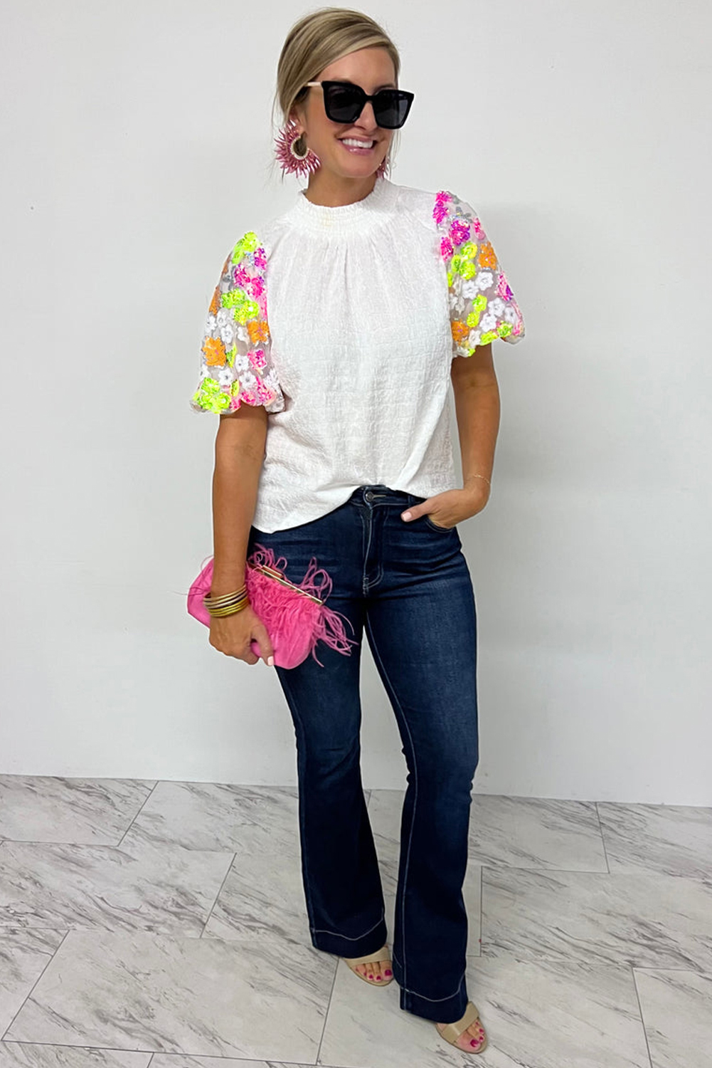 Add a touch of glamour to your wardrobe with this stunning Women's White Sequin Flower Puff Sleeve Textured Top. The sequined top catches the light beautifully, creating a dazzling effect that is perfect for special occasions. The crinkle textured fabric adds a unique and fashionable touch, while the smocked collar provides a structured and tailored look. The puff sleeves add a romantic and whimsical vibe, making it perfect for date nights or casual outings. Made from high-quality 100% polyester, this top ensures comfort and durability. The round neckline and elegant silhouette make it a versatile piece for any wardrobe. Pair it with your favorite jeans for a casual yet stylish look, or dress it up with a skirt for a more polished ensemble. This chic top is a must-have addition to elevate your everyday style. - Detail View 4 Add a touch of glamour to your wardrobe with this stunning Women's White Sequin Flower Puff Sleeve Textured Top. The sequined top catches the light beautifully, creating a dazzling effect that is perfect for special occasions. The crinkle textured fabric adds a unique and fashionable touch, while the smocked collar provides a structured and tailored look. The puff sleeves add a romantic and whimsical vibe, making it perfect for date nights or casual outings. Made from high-quality 100% polyester, this top ensures comfort and durability. The round neckline and elegant silhouette make it a versatile piece for any wardrobe. Pair it with your favorite jeans for a casual yet stylish look, or dress it up with a skirt for a more polished ensemble. This chic top is a must-have addition to elevate your everyday style. - Detail View 4
