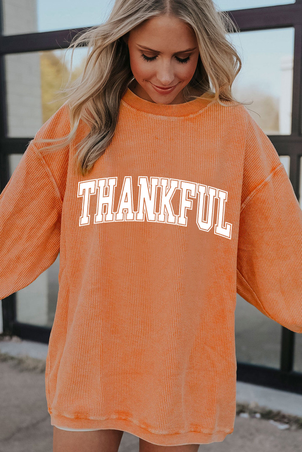 Stay warm and stylish with this Women's THANKFUL Orange Ribbed Crew Neck Pullover Sweatshirt. The bold THANKFUL graphic is a charming expression of gratitude, making it a perfect choice for Thanksgiving celebrations. The ribbed fabric provides a warm and textured feel, ensuring a cozy and comfortable fit. Pair it with your favorite jeans or casual pants for a stylish and comfortable outfit. This graphic sweatshirt is a great addition to your winter wardrobe, featuring a fun and festive design. - Detail View 4 Stay warm and stylish with this Women's THANKFUL Orange Ribbed Crew Neck Pullover Sweatshirt. The bold THANKFUL graphic is a charming expression of gratitude, making it a perfect choice for Thanksgiving celebrations. The ribbed fabric provides a warm and textured feel, ensuring a cozy and comfortable fit. Pair it with your favorite jeans or casual pants for a stylish and comfortable outfit. This graphic sweatshirt is a great addition to your winter wardrobe, featuring a fun and festive design. - Detail View 4