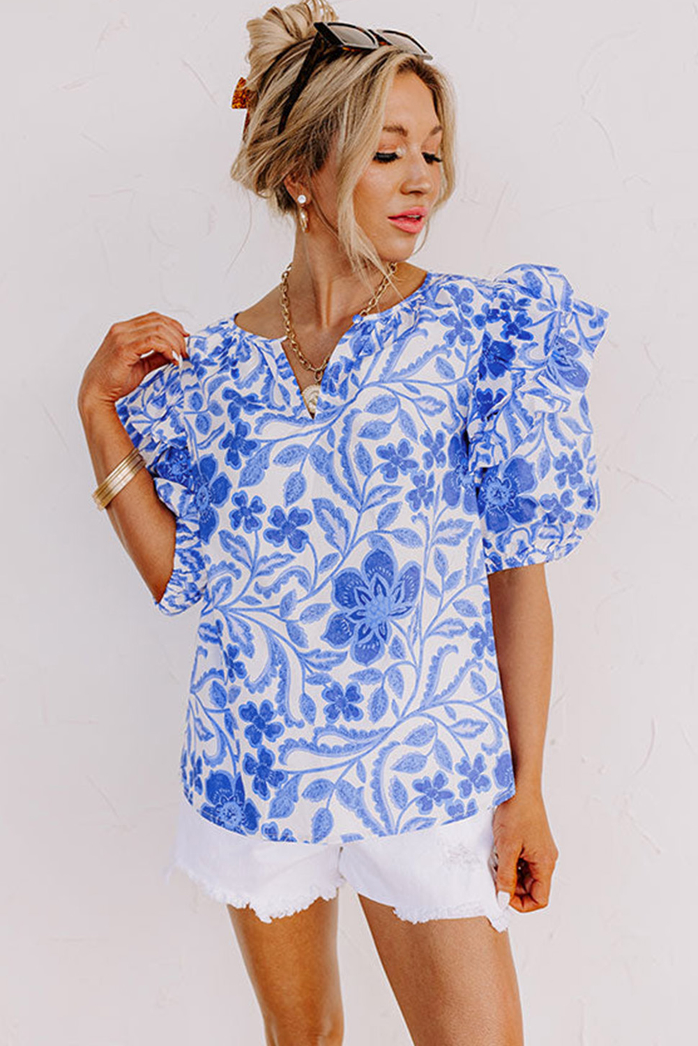 Elevate your wardrobe with this Women's Dark Blue Floral Print Ruffled Bubble Sleeve Blouse. Featuring a charming floral print, this blouse creates an eye-catching and feminine look. The playful ruffled bubble sleeves add a touch of whimsy and flair to the top, while the stylish notched neck detail provides a modern twist. Embrace elegance with the bubble sleeve design, adding a chic and sophisticated element to your outfit. Made from 100% cotton, this blouse ensures comfort and breathability for all-day wear. Perfect for daily occasions and summer outings, this versatile blouse is a must-have for any fashion-forward woman looking to update her wardrobe with on-trend styles. - Detail View 4 Elevate your wardrobe with this Women's Dark Blue Floral Print Ruffled Bubble Sleeve Blouse. Featuring a charming floral print, this blouse creates an eye-catching and feminine look. The playful ruffled bubble sleeves add a touch of whimsy and flair to the top, while the stylish notched neck detail provides a modern twist. Embrace elegance with the bubble sleeve design, adding a chic and sophisticated element to your outfit. Made from 100% cotton, this blouse ensures comfort and breathability for all-day wear. Perfect for daily occasions and summer outings, this versatile blouse is a must-have for any fashion-forward woman looking to update her wardrobe with on-trend styles. - Detail View 4